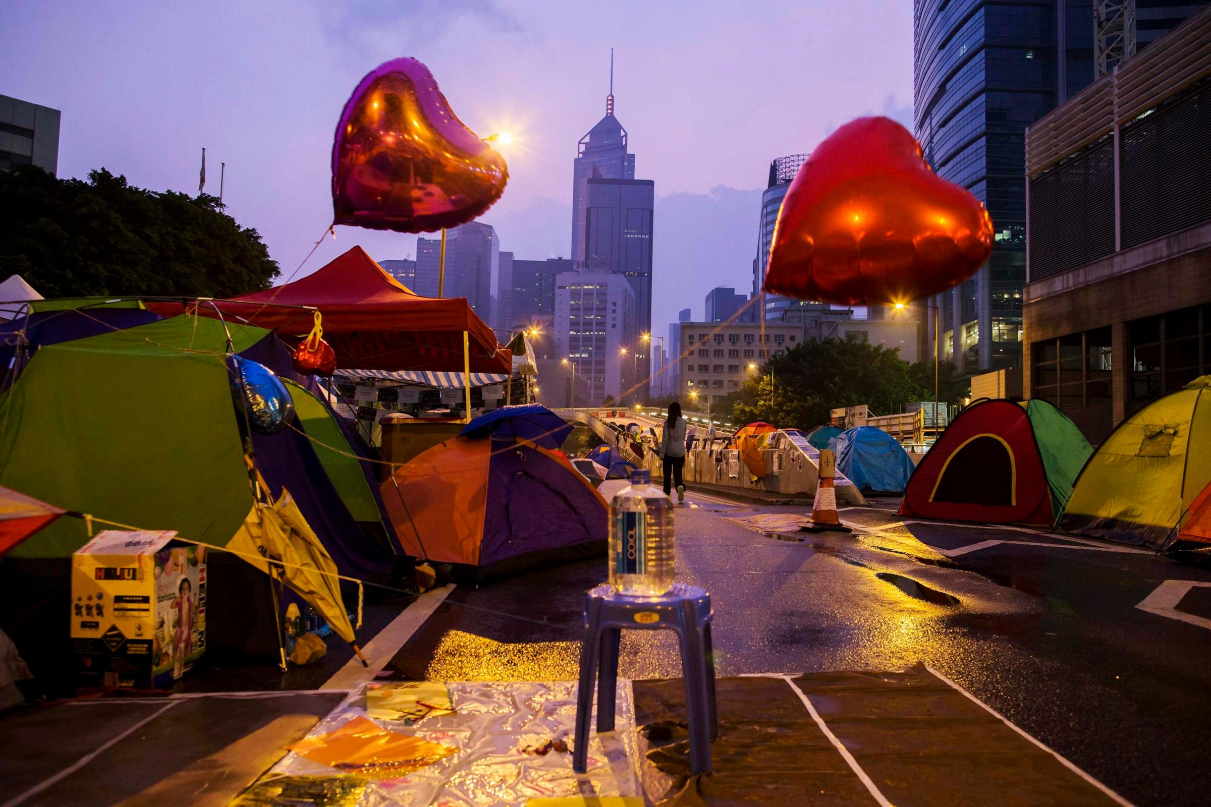 An Occupy Central protester walks past tents before sunrise on a main road leading to the financial Central district in Hong Kong on Oct. 16, 2014.