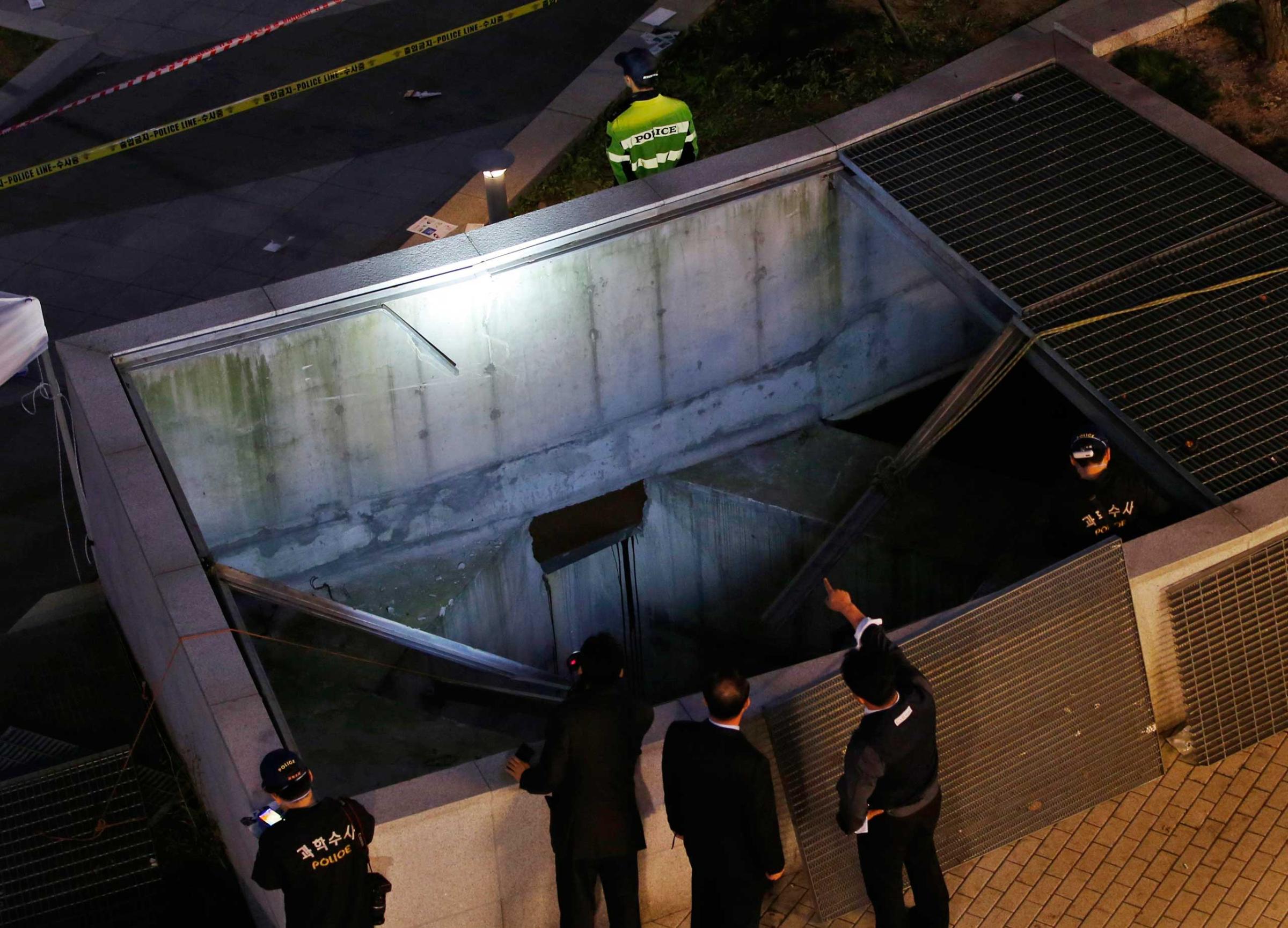 Police officials examine the scene of an accident at a shopping district in Seongnam