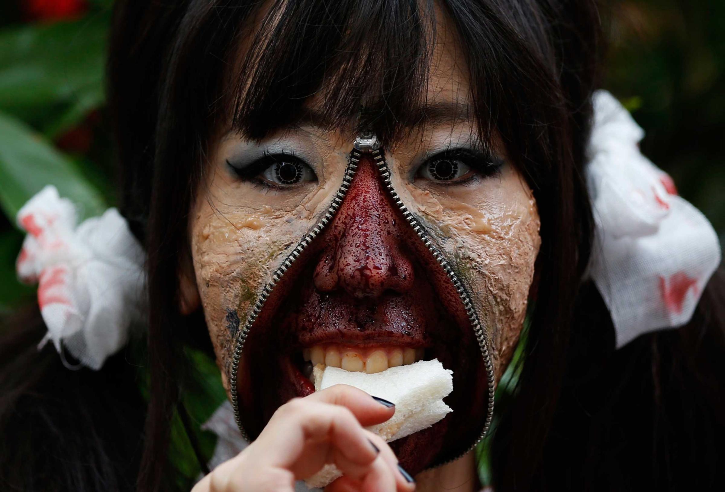 A participant in costume eats a sandwich after a Halloween parade in Kawasaki