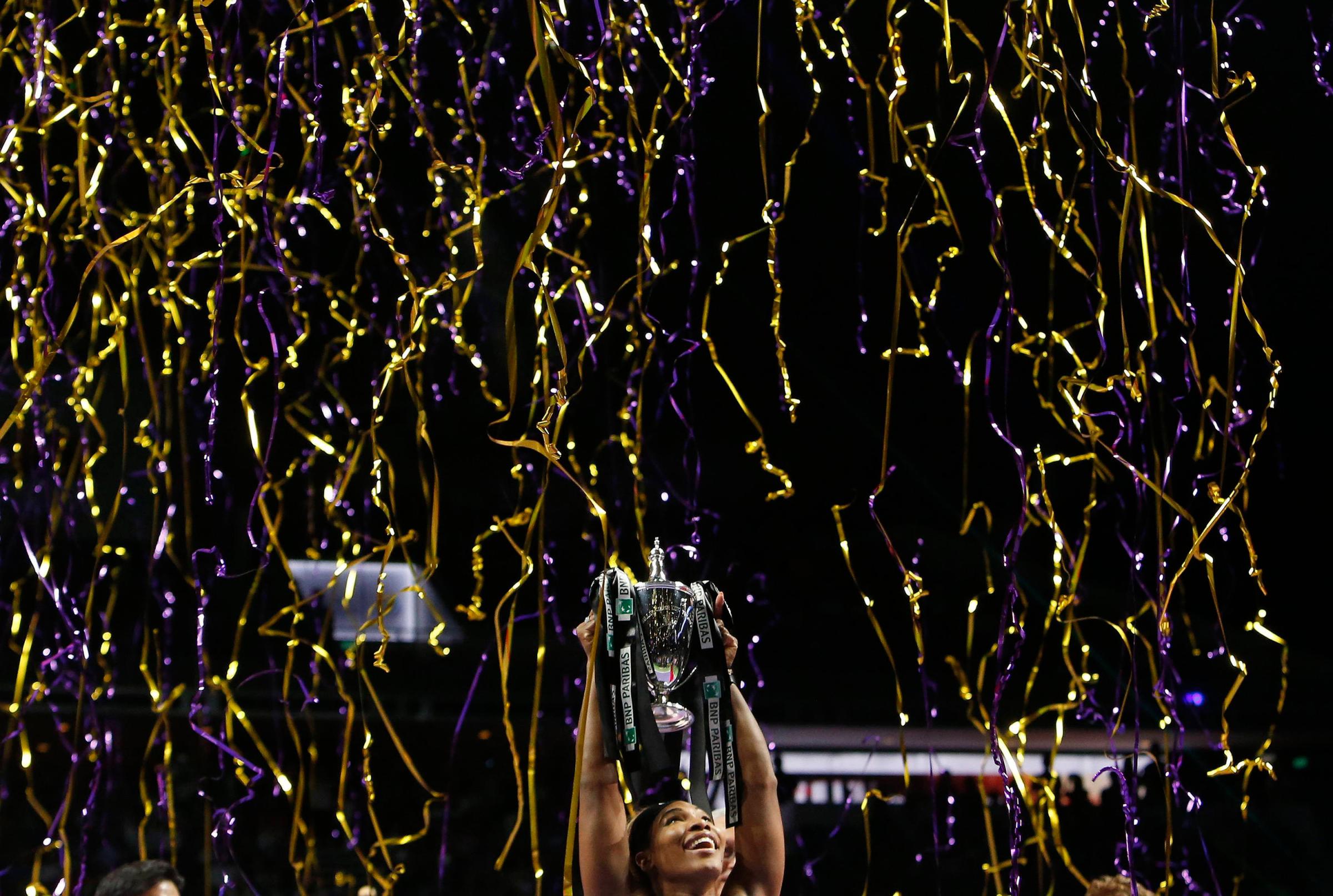 Serena Williams of the U.S. poses with the trophy after defeating Simona Halep of Romania in the women's singles final tennis match of the WTA Finals at the Singapore Indoor Stadium on October 26, 2014.