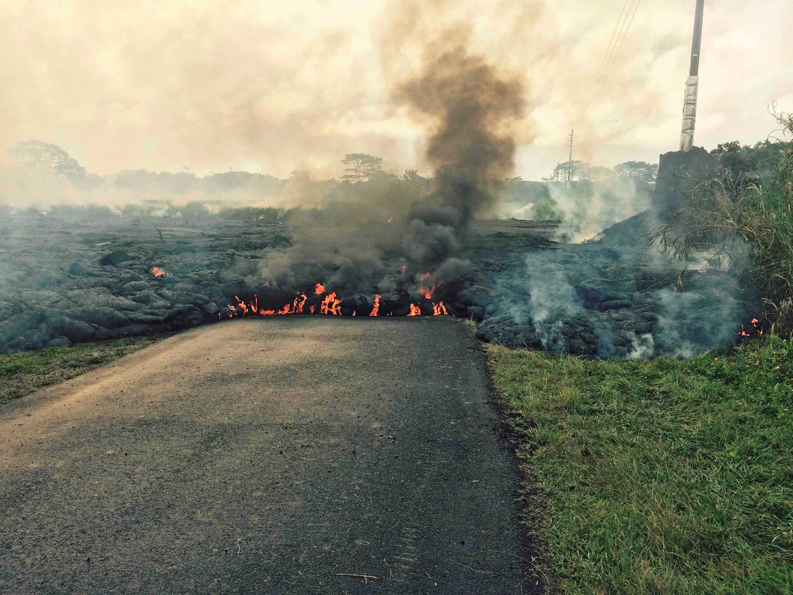The lava flow from the Kilauea Volcano is seen crossing Apa'a Street/Cemetery Road in this U.S. Geological Survey (USGS) image taken near the village of Pahoa, Hawaii Oct. 25, 2014. (USGS/Reuters)