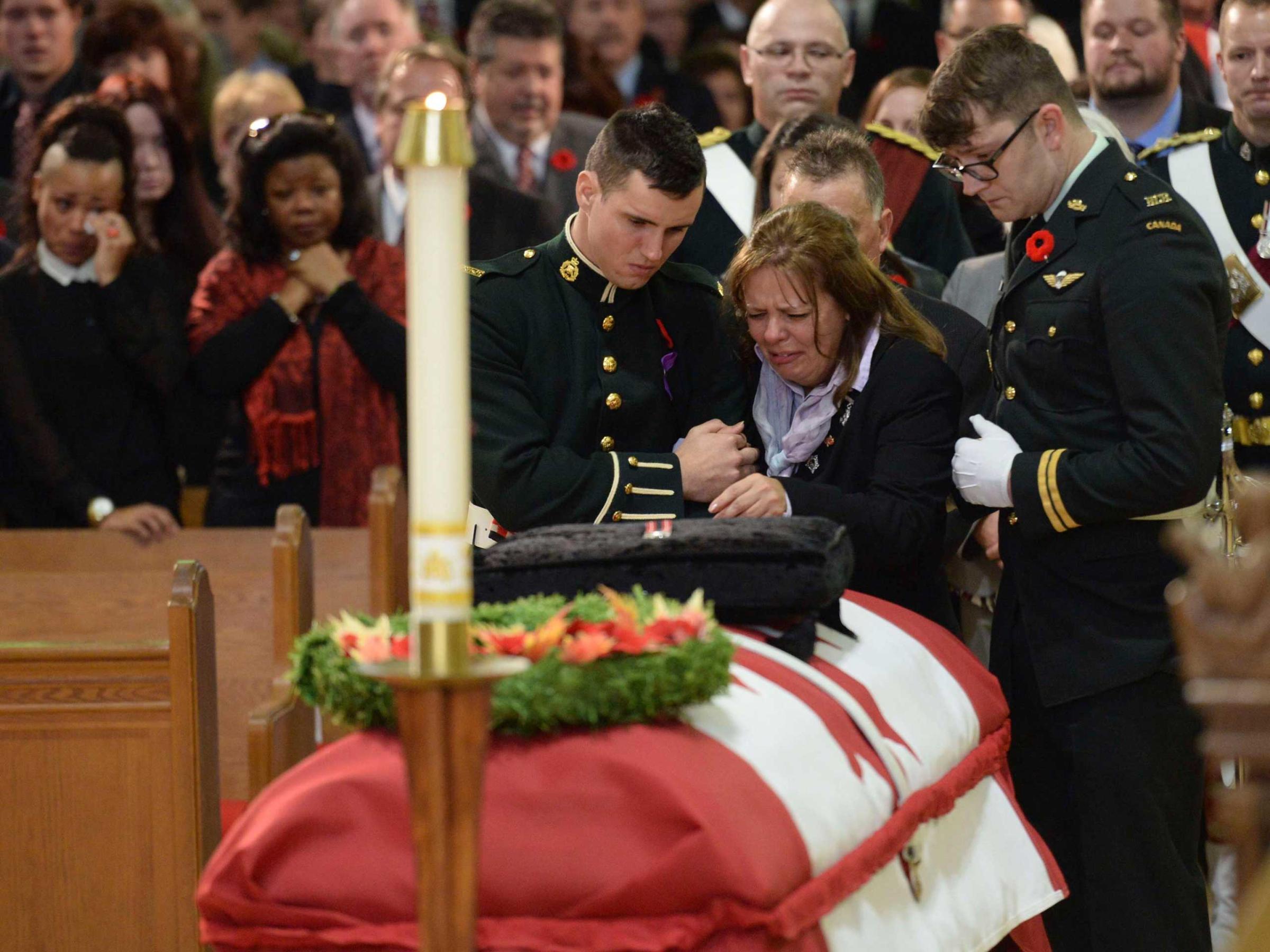 Cirillo is comforted in front of the coffin of her son Cpl. Nathan Cirillo at his regimental funeral service in Hamilton, Ontario