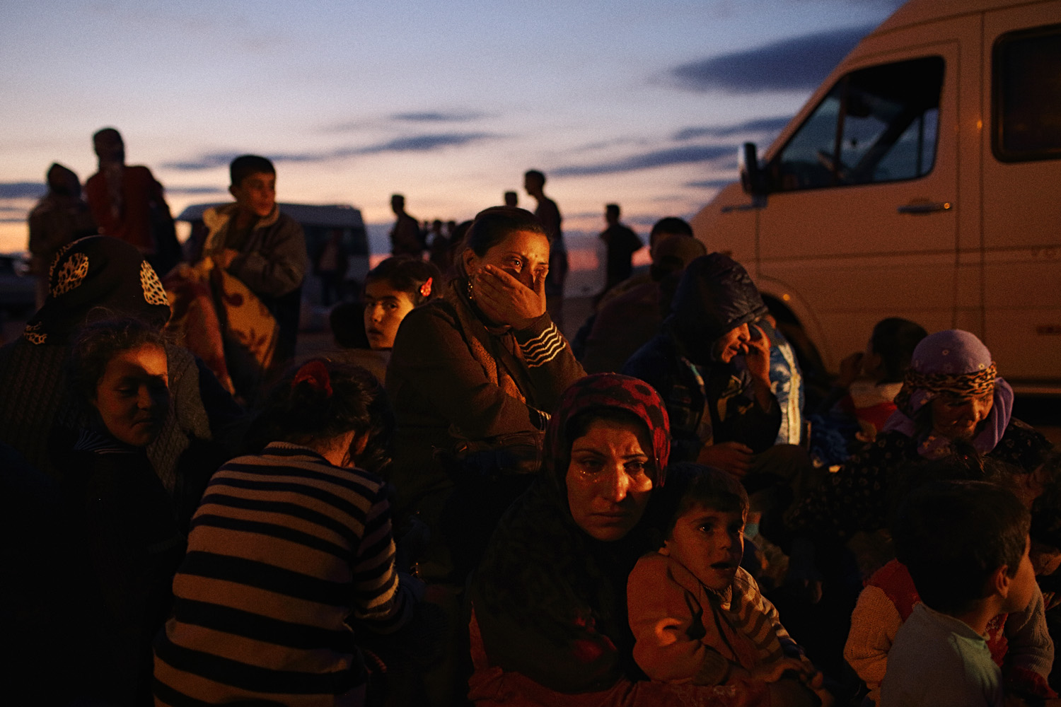 Women from Kobani wait with their children on the Turkish side of the border.