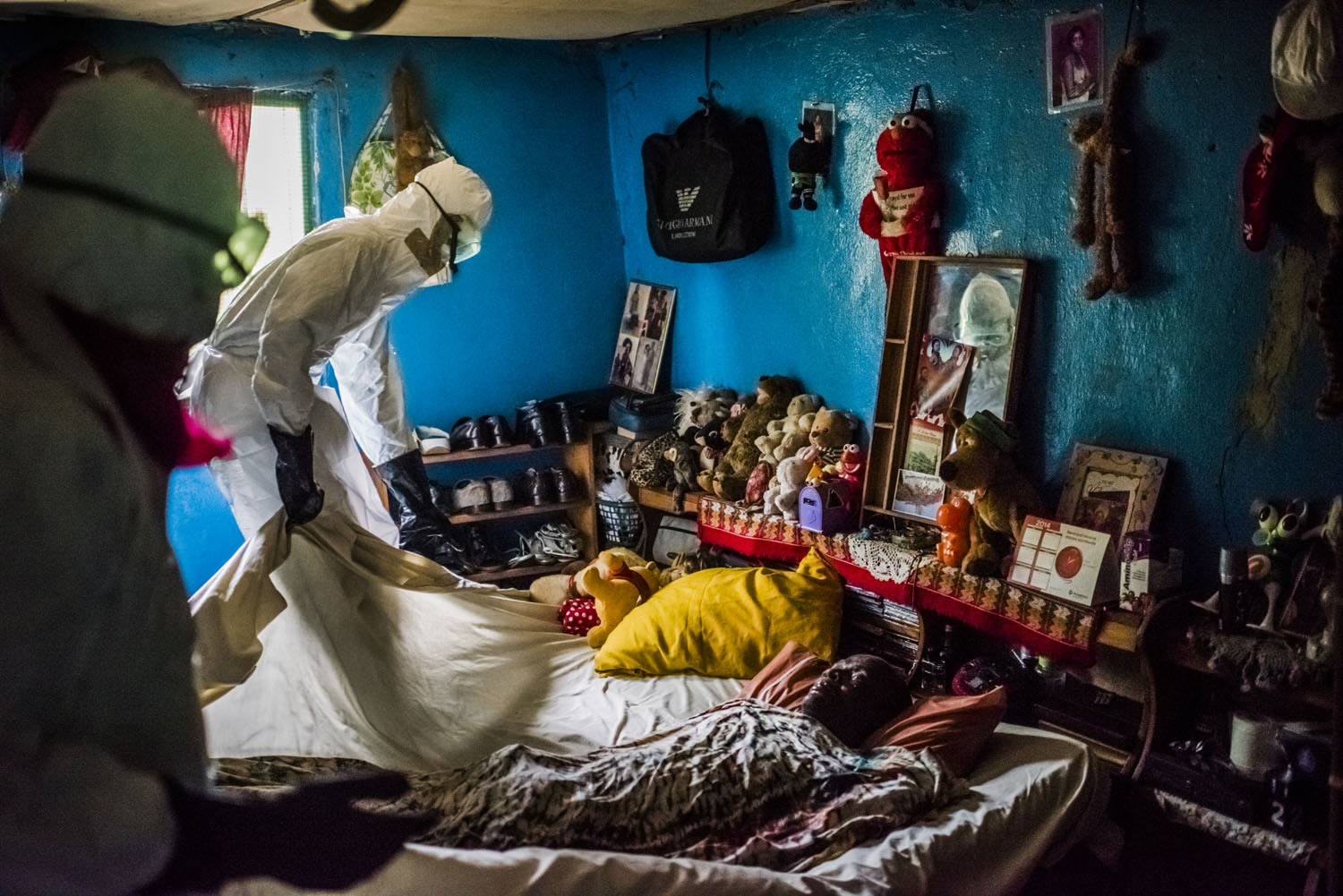 Members of a burial team from the Liberian Red Cross under contract from the Liberian Ministry of Health remove the body of a man, a suspected Ebola victim from a home in Matadi on Sept. 17, 2014 in Monrovia, Liberia.