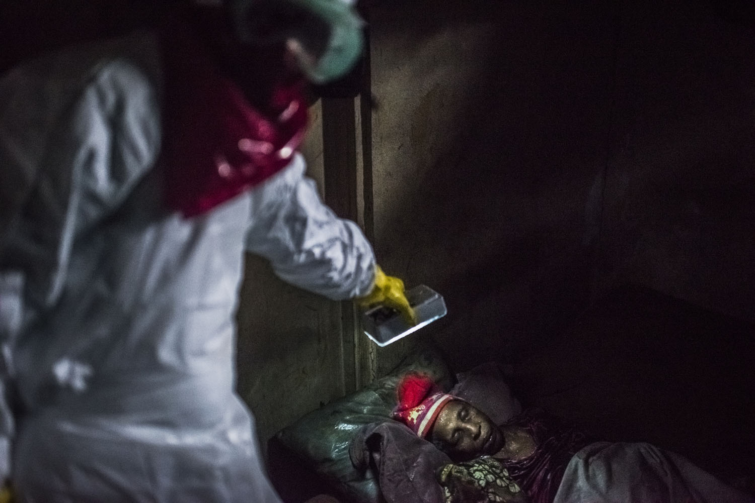 Members of a Liberian Red Cross burial team, remove the body of woman, a woman, 75, a suspected Ebola victim on Sept. 18, 2014 in Monrovia, Liberia.