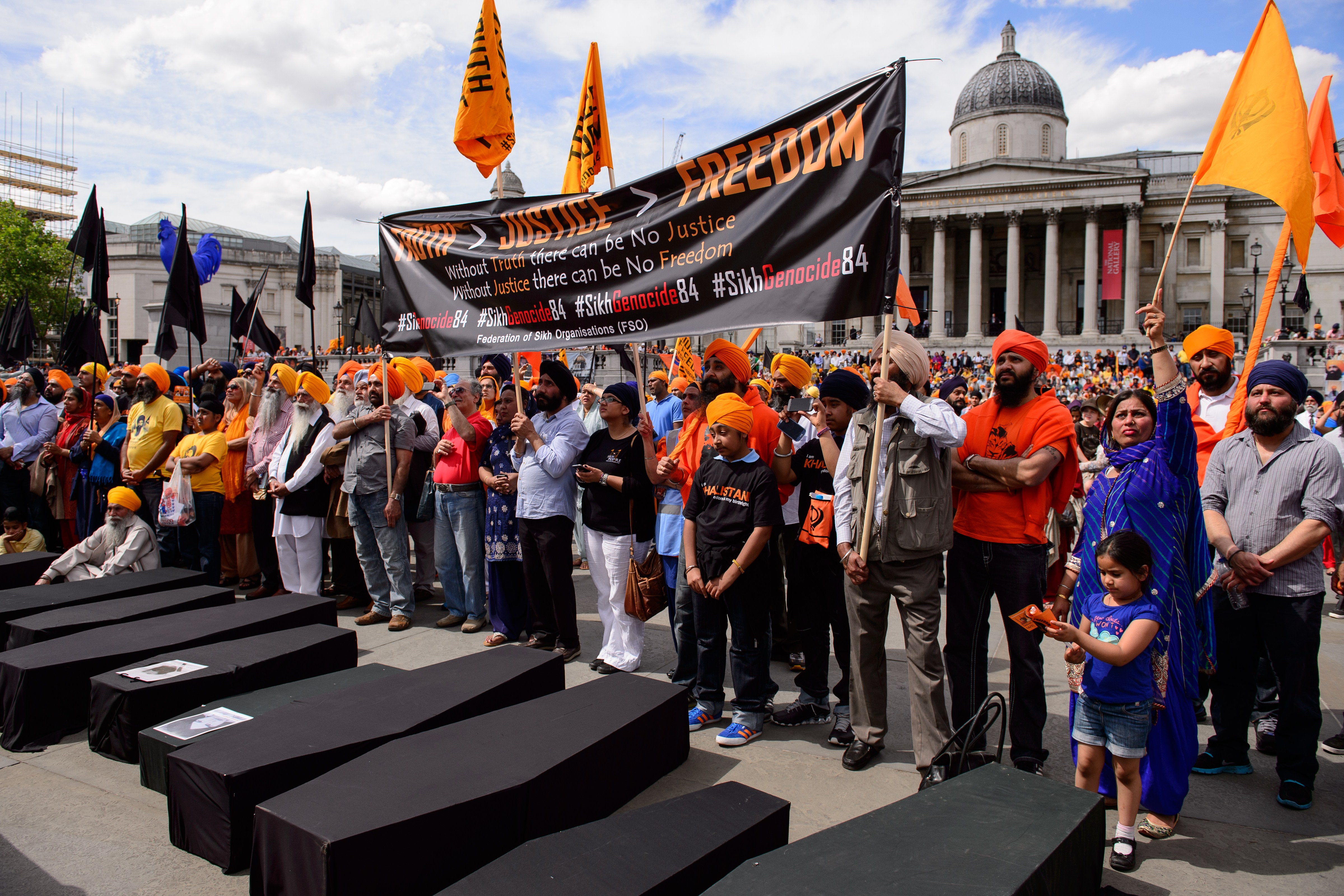 Members of the Sikh community hold aloft a banner calling for the 1984 storming of Sikhism's holiest shrine, the Golden Temple in Amritsar, by Indian troops, to be recognised as genocide as they join a demonstration in central London on June 8, 2014, to mark the 30th anniversary of the assault known as Operation Blue Star. (LEON NEAL&mdash;AFP/Getty Images)