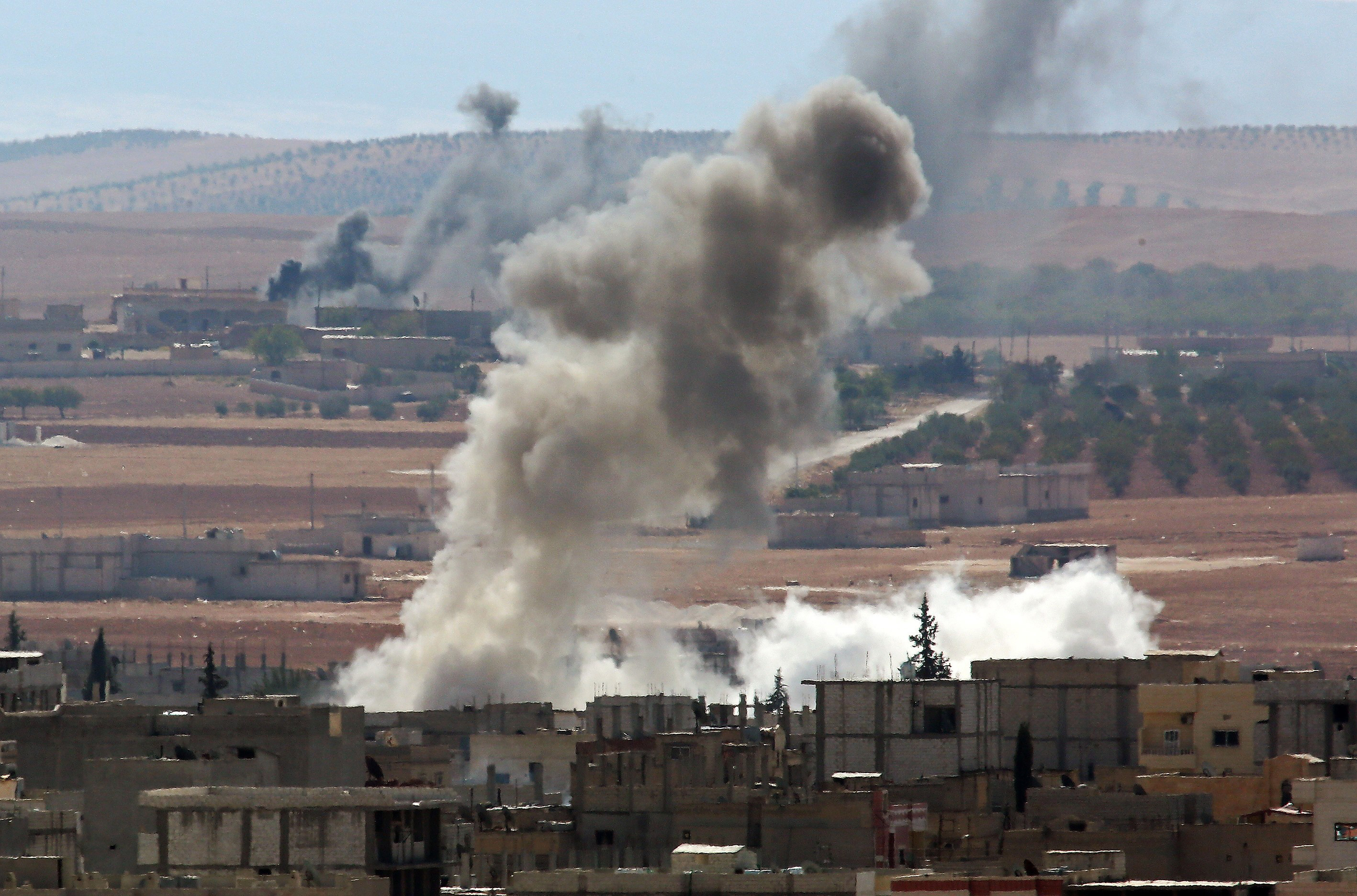 Smoke rising from the Syrian town of Kobani Thursday marks where clashes between its Kurdish defenders and ISIS attackers are underway. (Emin Menguarslan / Anadolu Agency / Getty Images)