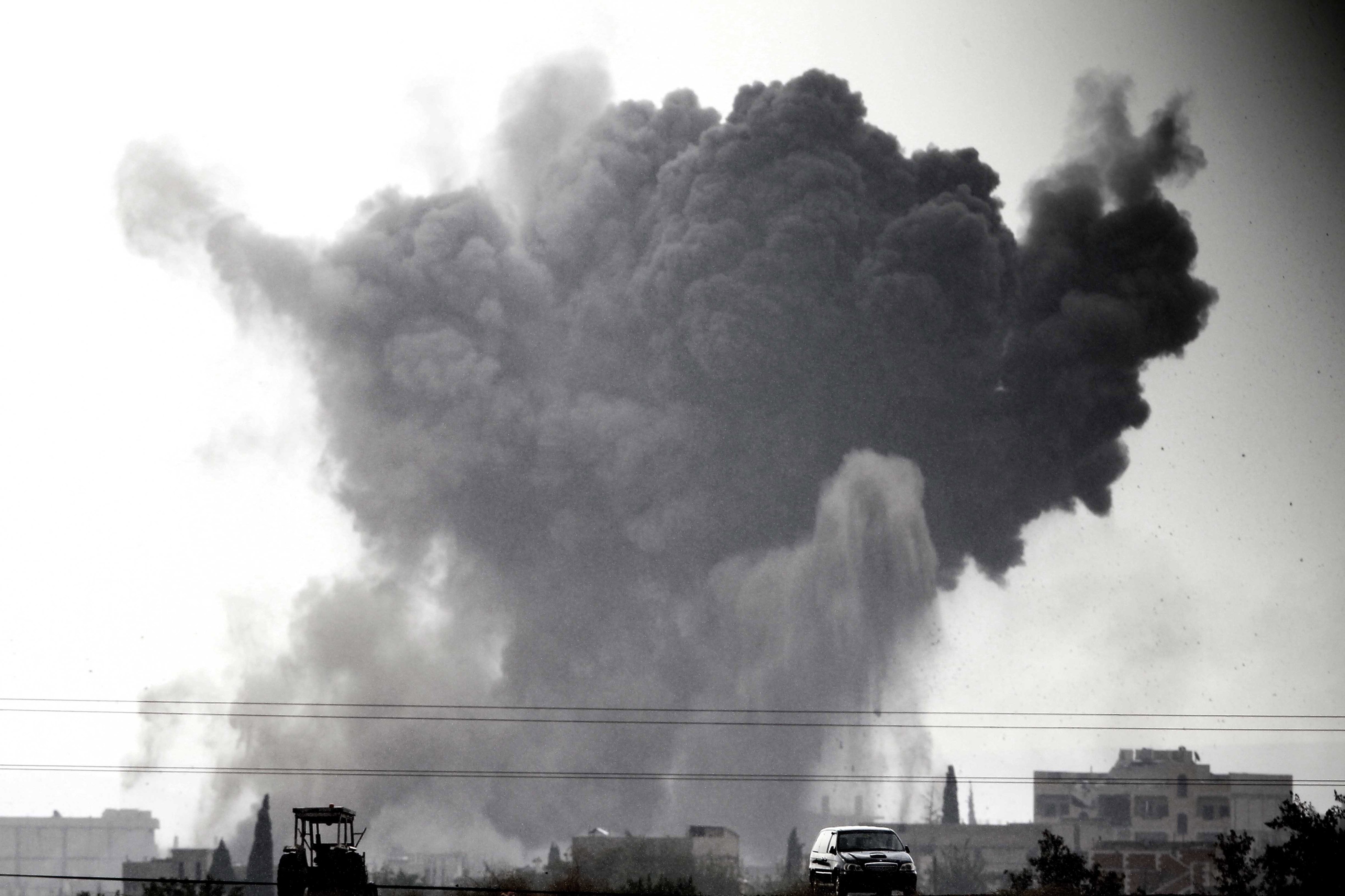 Smoke billows following an airstrike by US-led coalition aircraft in Kobani, Syria, during fighting between Syrian Kurds and militants from Islamic State, on October 14, 2014 as seen from the outskirts of Suruc, on the Turkey-Syria border. (Gokhan Sahin—Getty Images)