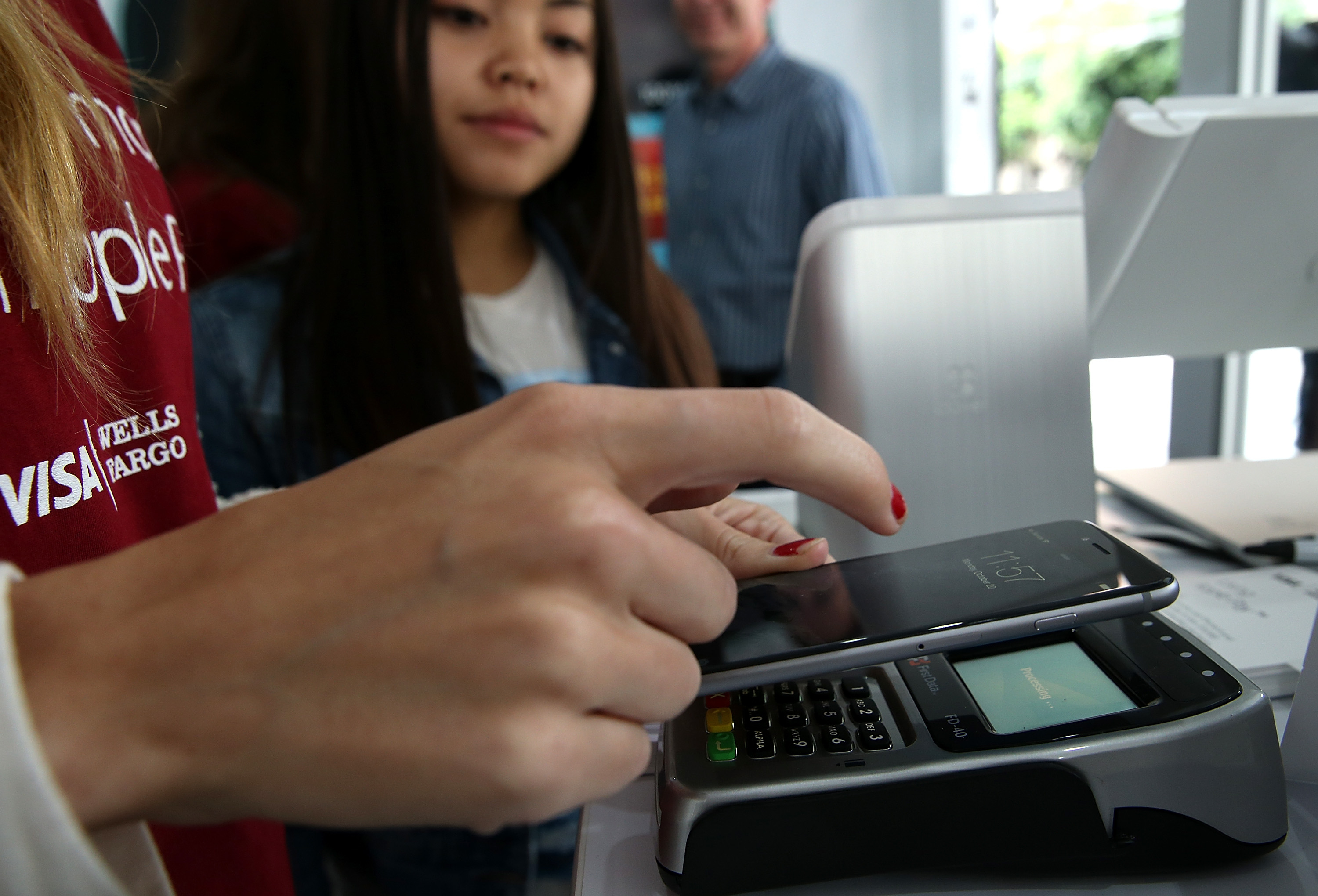 A worker demonstrates Apple Pay inside a mobile kiosk sponsored by Visa and Wells Fargo to demonstrate the new Apple Pay mobile payment system on October 20, 2014 in San Francisco City. (Justin Sullivan&mdash;Getty Images)