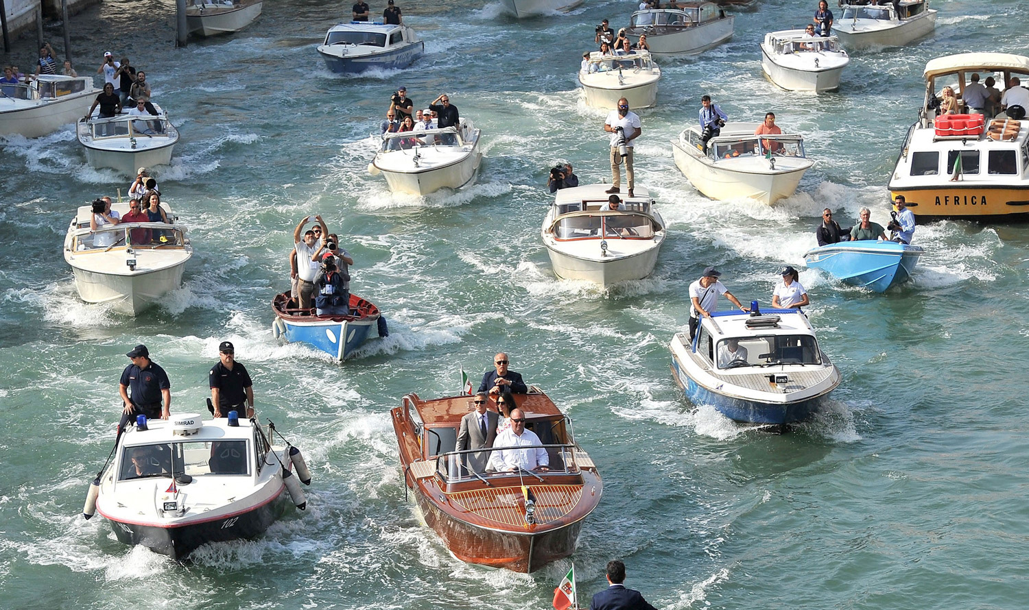 George Clooney and Amal
                              Alamuddin, a human-rights lawyer, are
                              followed by more than a dozen boats holding
                              security and media after leaving a hotel in
                              Venice on Sept. 28; they had wedded the day before.