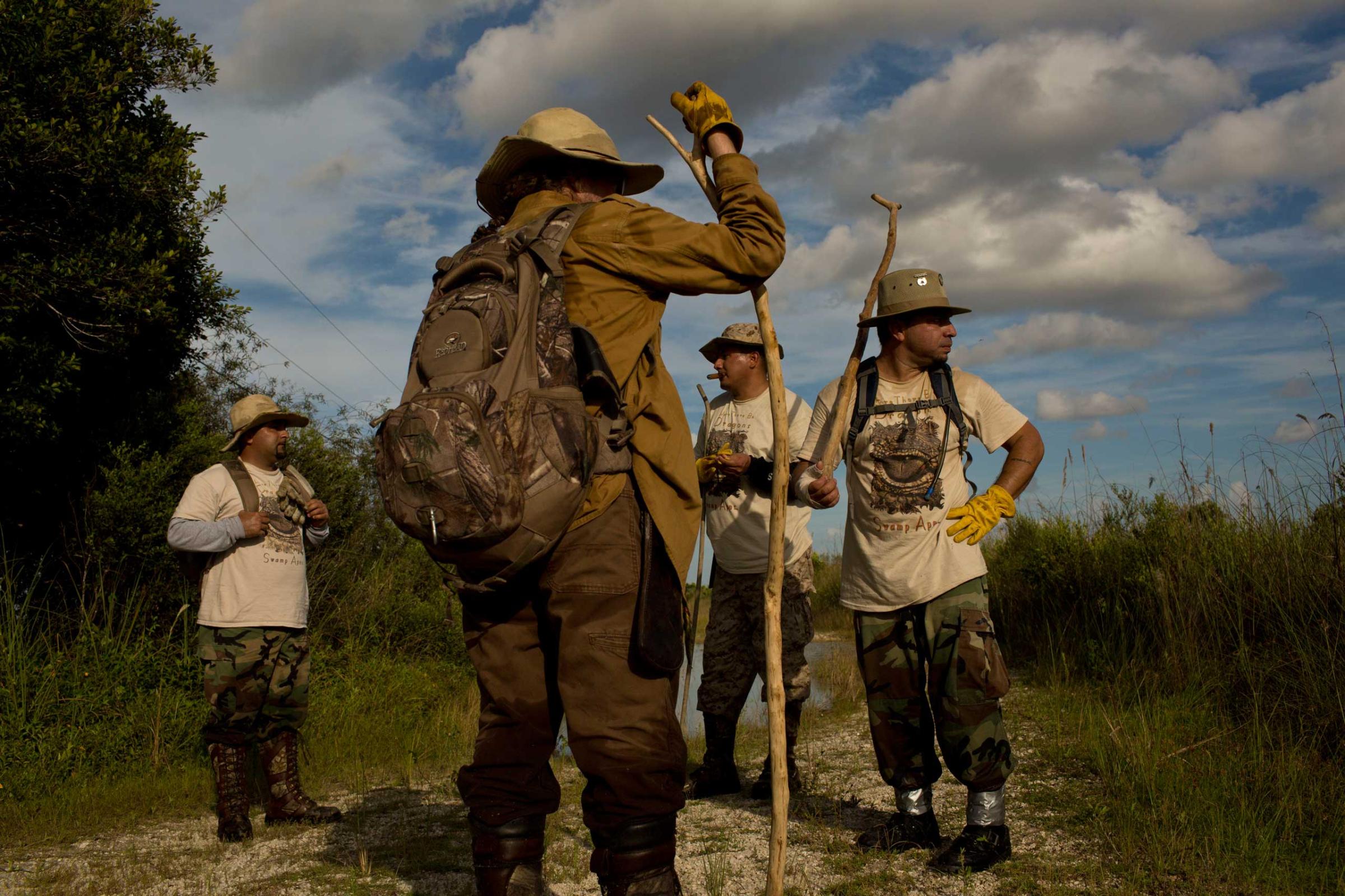 Founder of the "Swamp Apes" Tom Rahill speaks to veterans and volunteer members of the group during a patrol through Florida's Everglades National Park searching for invasive pythons in the Chekika area of the park on Saturday Oct. 4, 2014. From left to right are Jorge Martinez, Rahill, Jose Rodriguez, and Alex Nunez. (David Guttenfelder for TIME)