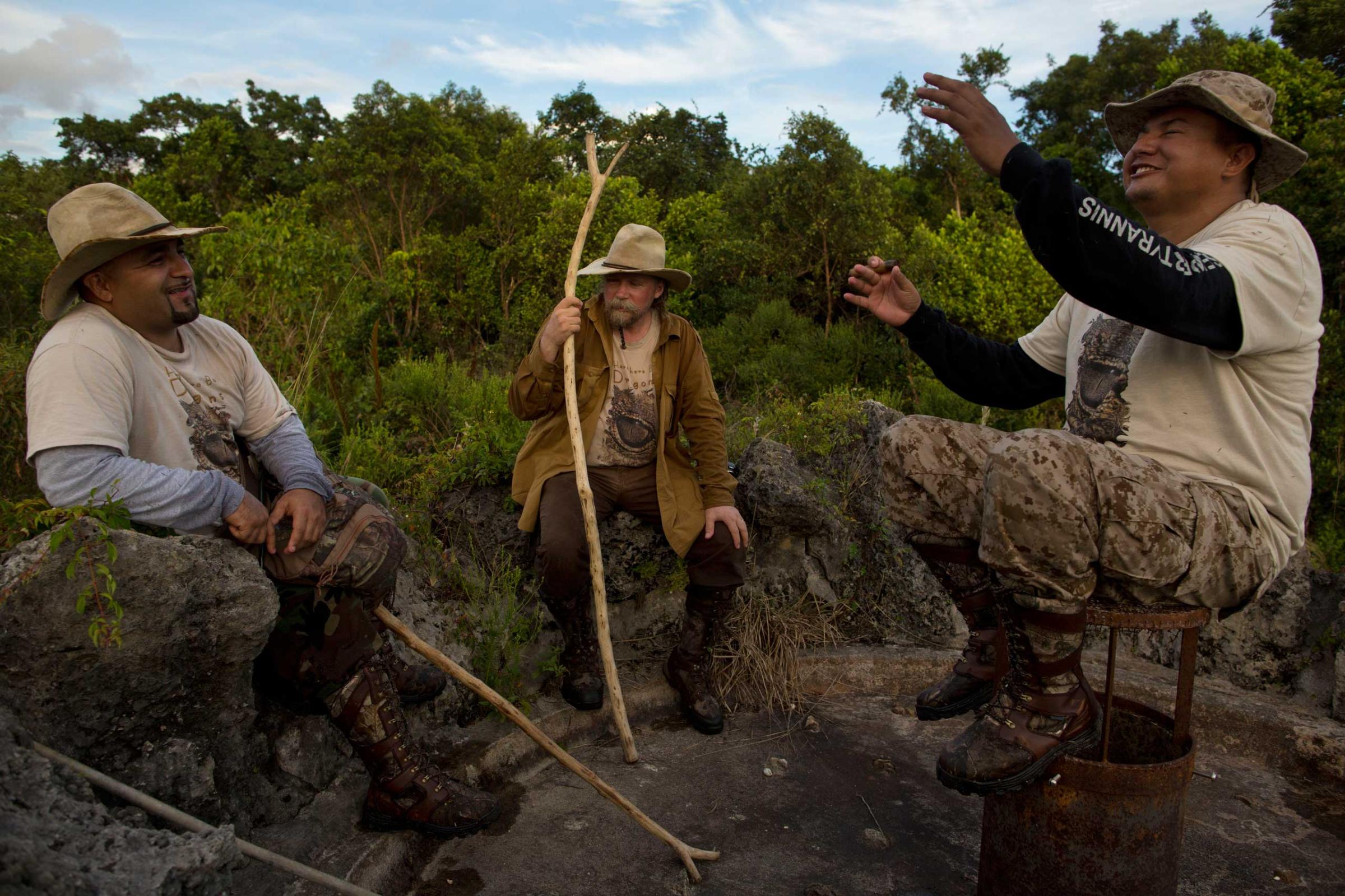 Members of the "Swamp Apes" rest and tell stories on an abandoned hot spring fountain during a patrol through Florida's Everglades National Park searching for invasive pythons in the Chekika area of the park on Saturday Oct. 4, 2014. From left to right are founder of the "Swamp Apes" Tom Rahill, center, and veteran and volunteer with the group Jorge Martinez, left, and Jose Rodriguez, right. David Guttenfelder for TIME)