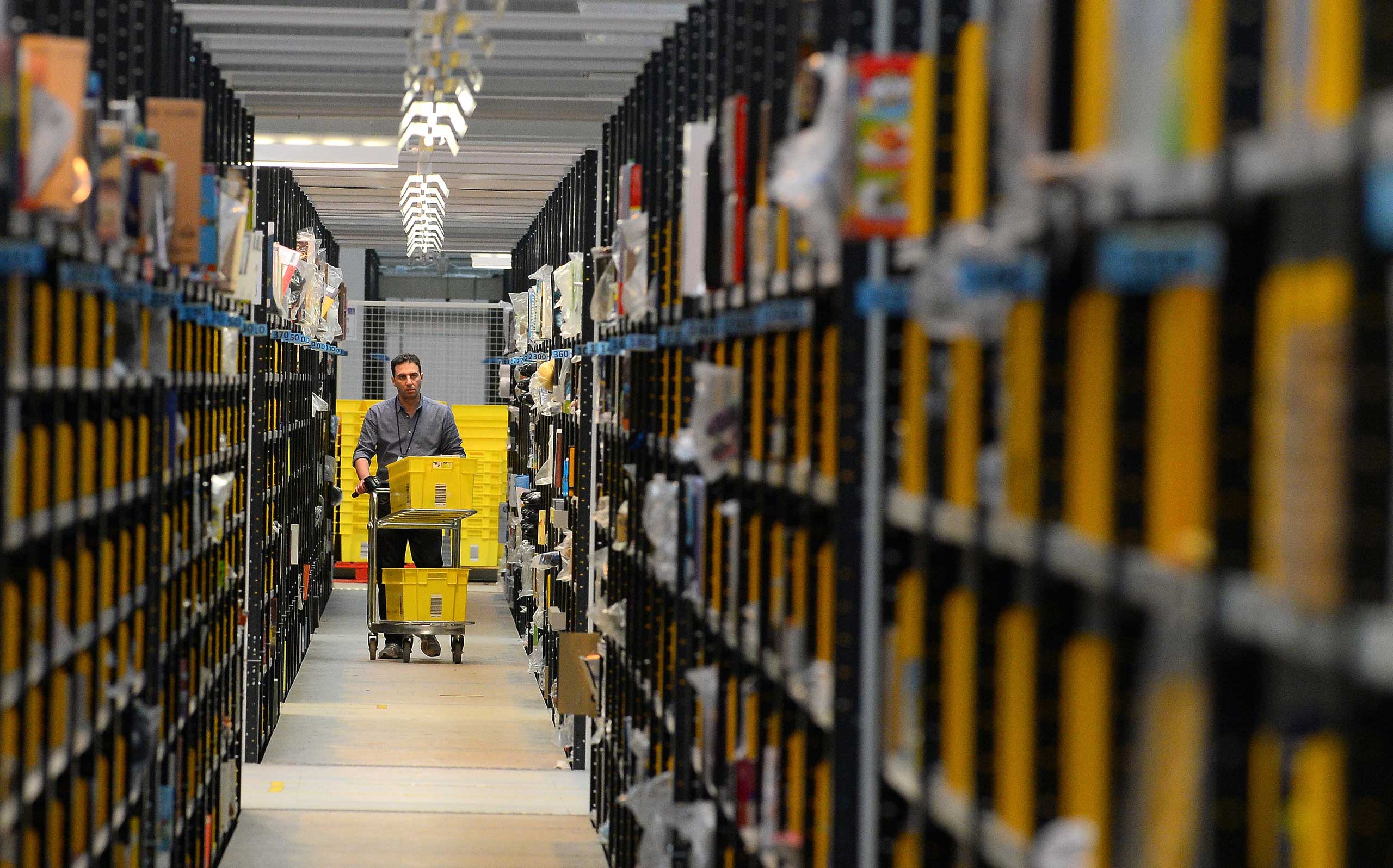 A worker collects order items at the Fulfilment Centre for online retail giant Amazon in Peterborough, central England, on Nov. 28, 2013.