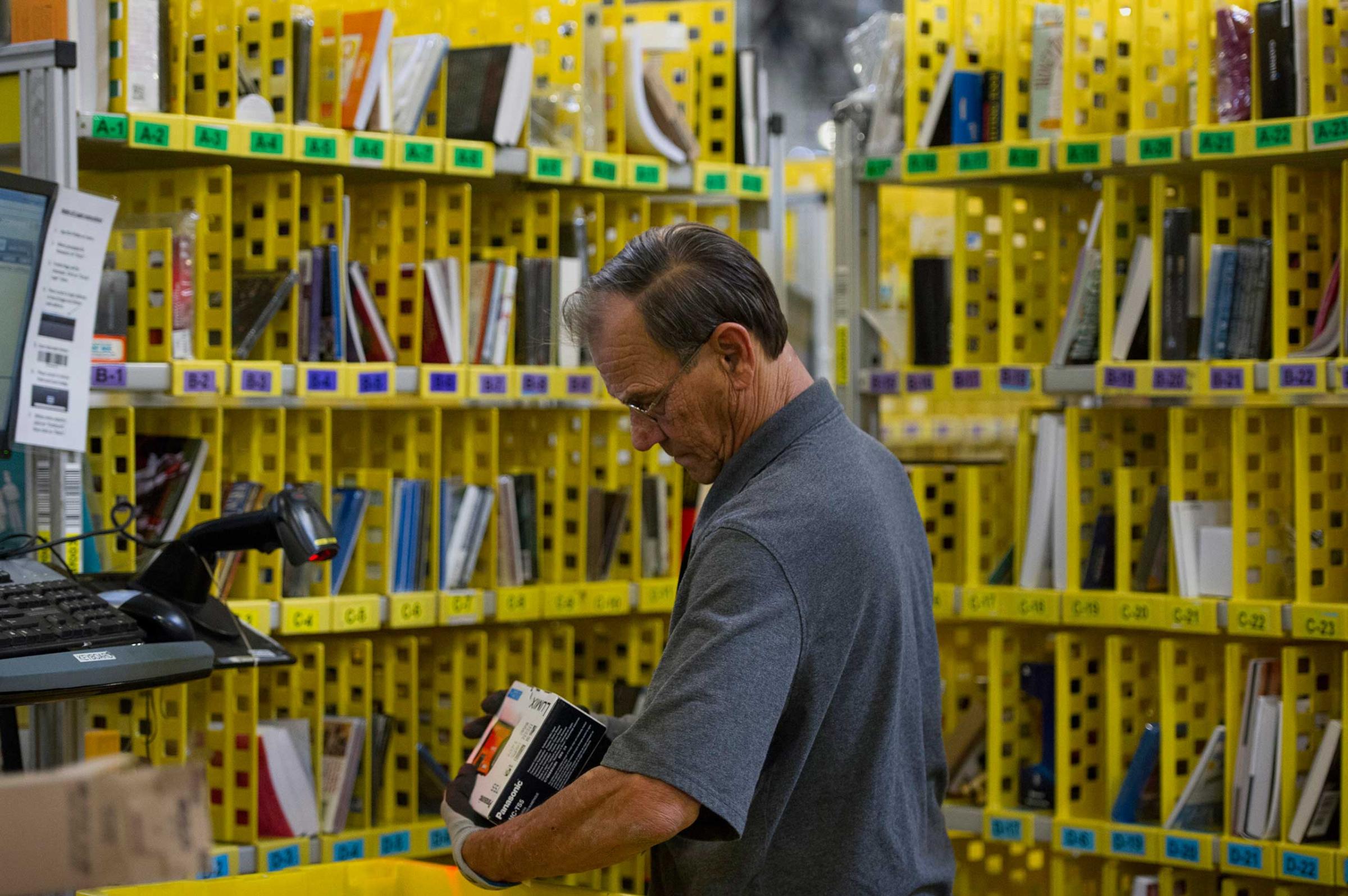 An employee packs merchandise for shipment at the Amazon.com Inc. fulfillment center in Phoenix, Arizona, Dec. 2, 2013.