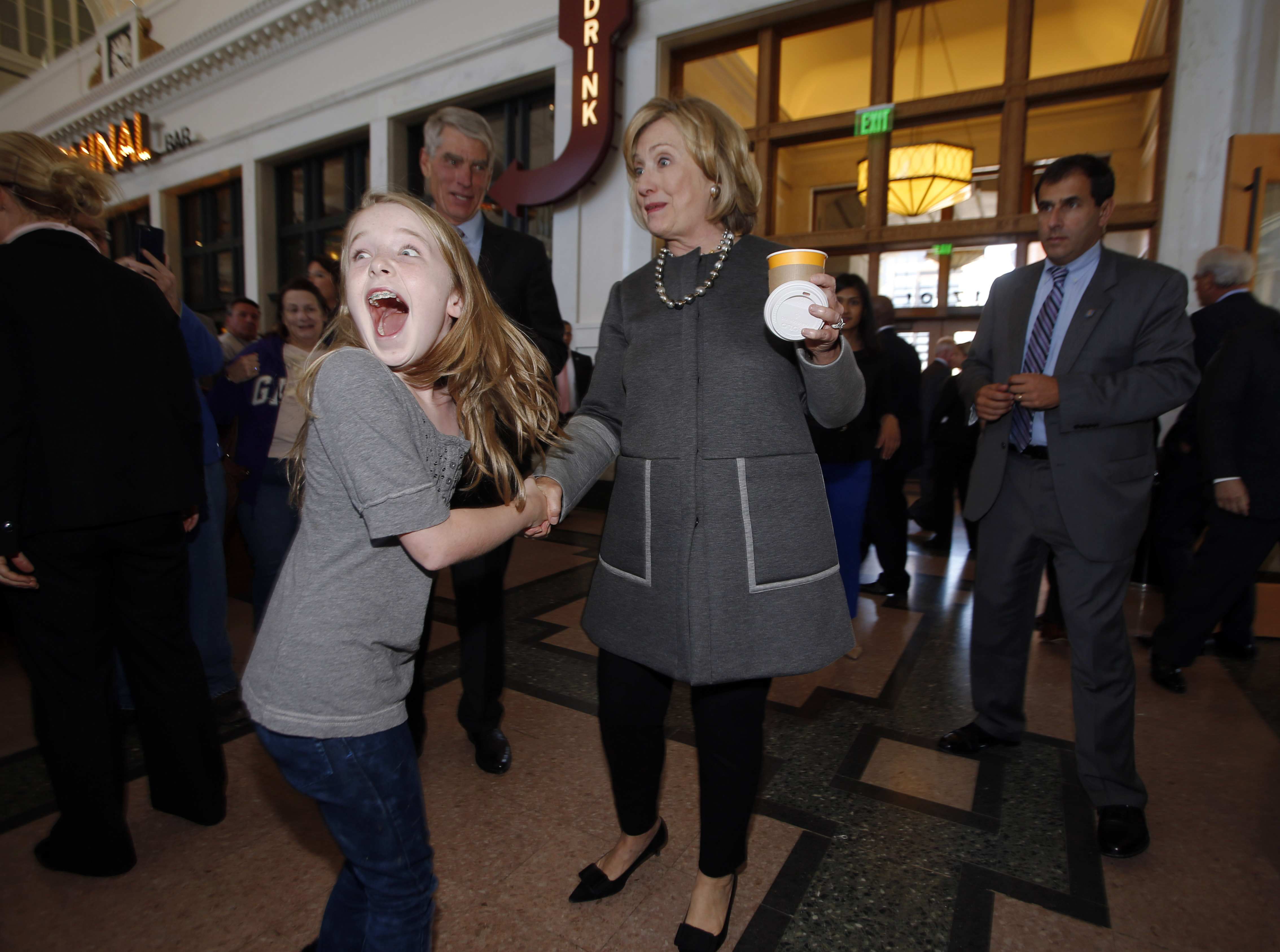 Ten-year-old Macy Friday, front left, reacts as she looks back at her family after meeting Hillary Clinton, front right, as she campaigns for U.S. Sen. Mark Udall, D-Colo., back, during a stop in Denver on Monday, Oct. 13, 2014. (David Zalubowski&mdash;AP)