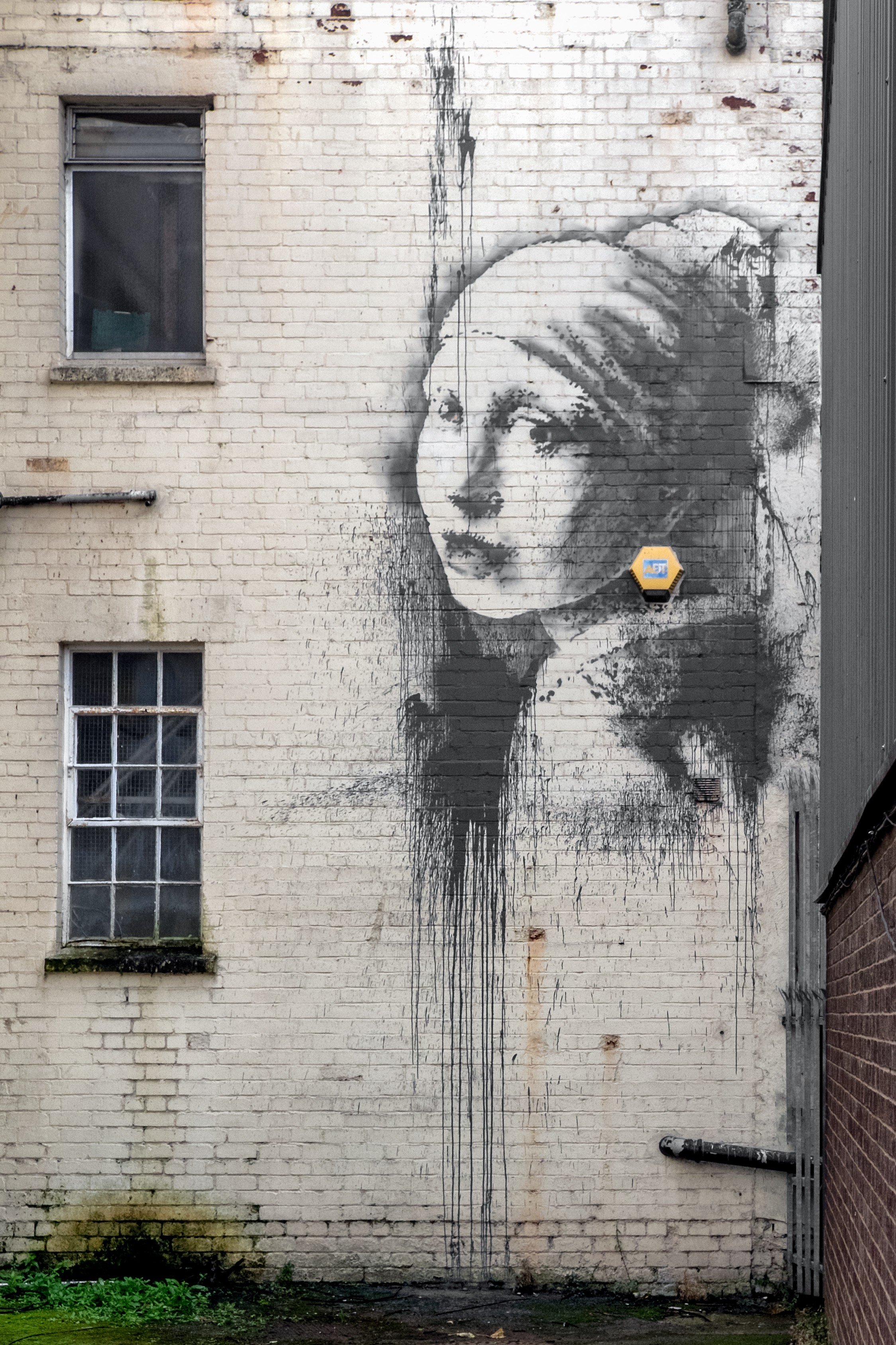 The new Banksy depicting the painting 'Girl with a Pearl Earring' by Dutch painter Johannes Vermeer is see on a wall in Bristol Harbourside, England on Oct. 20, 2014.