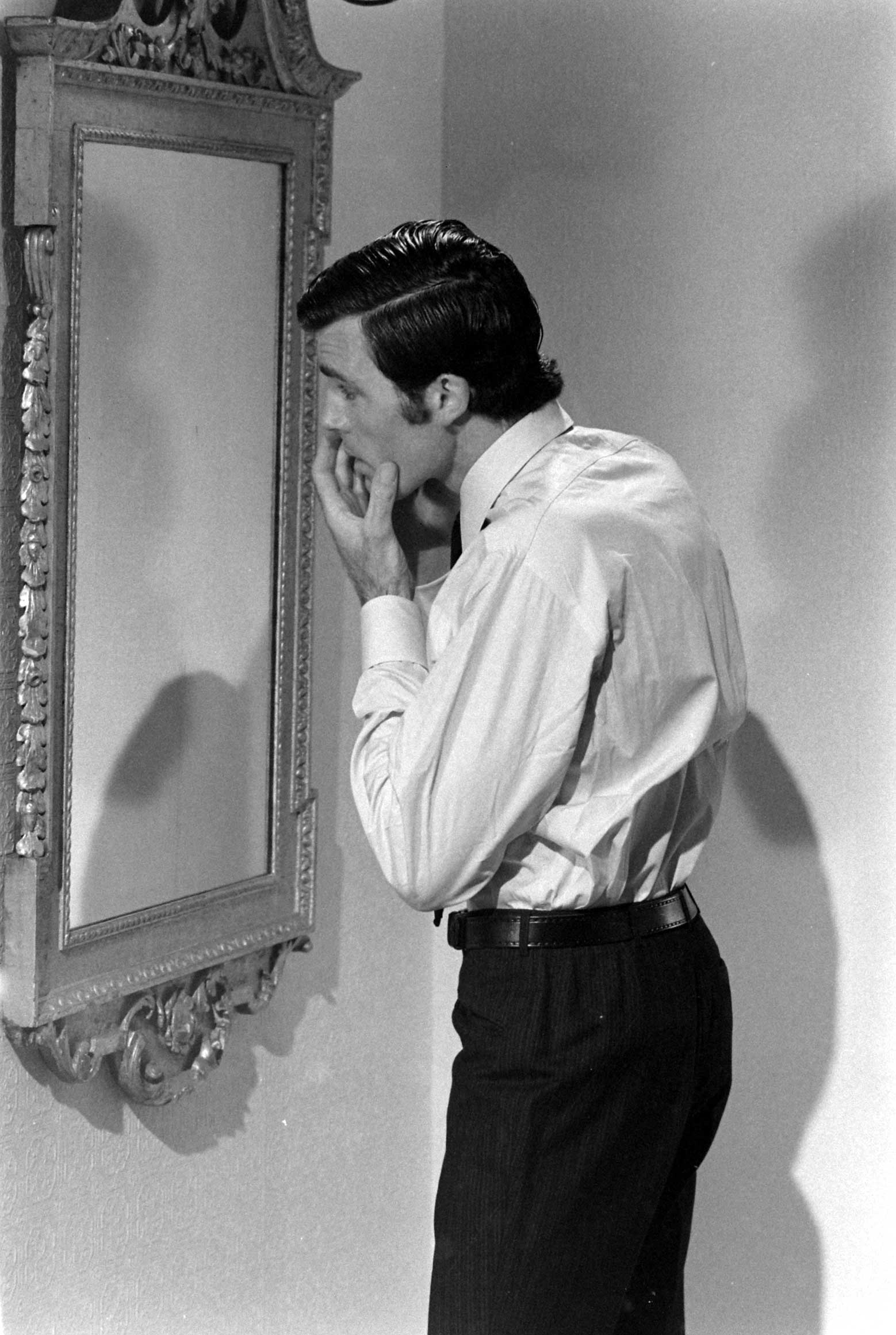 Robert Campbell looks in the mirror between filming scenes for his James Bond audition, 1967.