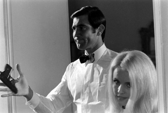 George Lazenby twirls a gun beside potential Bond Girl Marie-France Boyer, 1967.