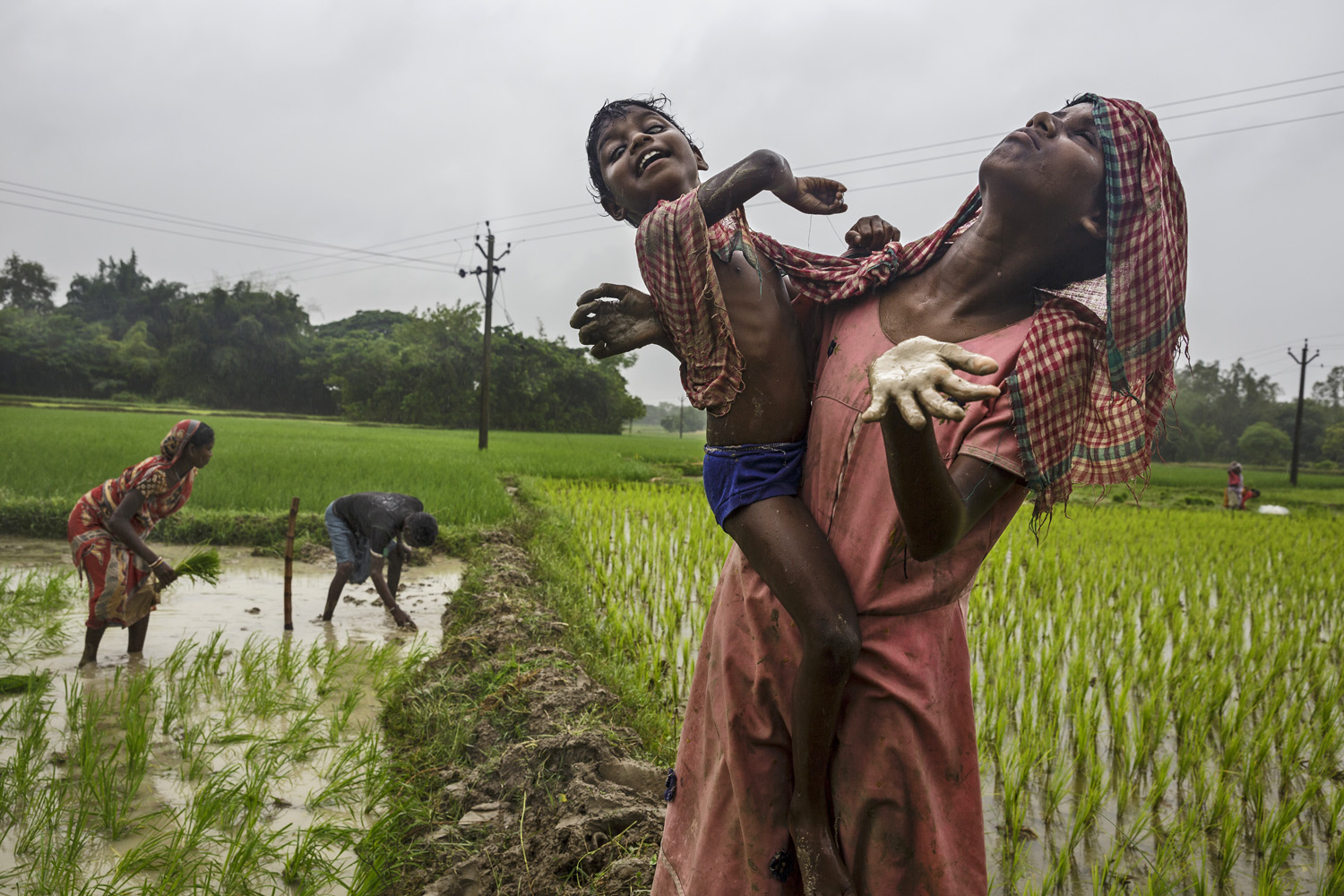 Sisters Sonia, right, and Anita Singh, who are both blind, let rain fall on their faces as their parents work nearby (Brent Stirton—Reportage by Getty Images)