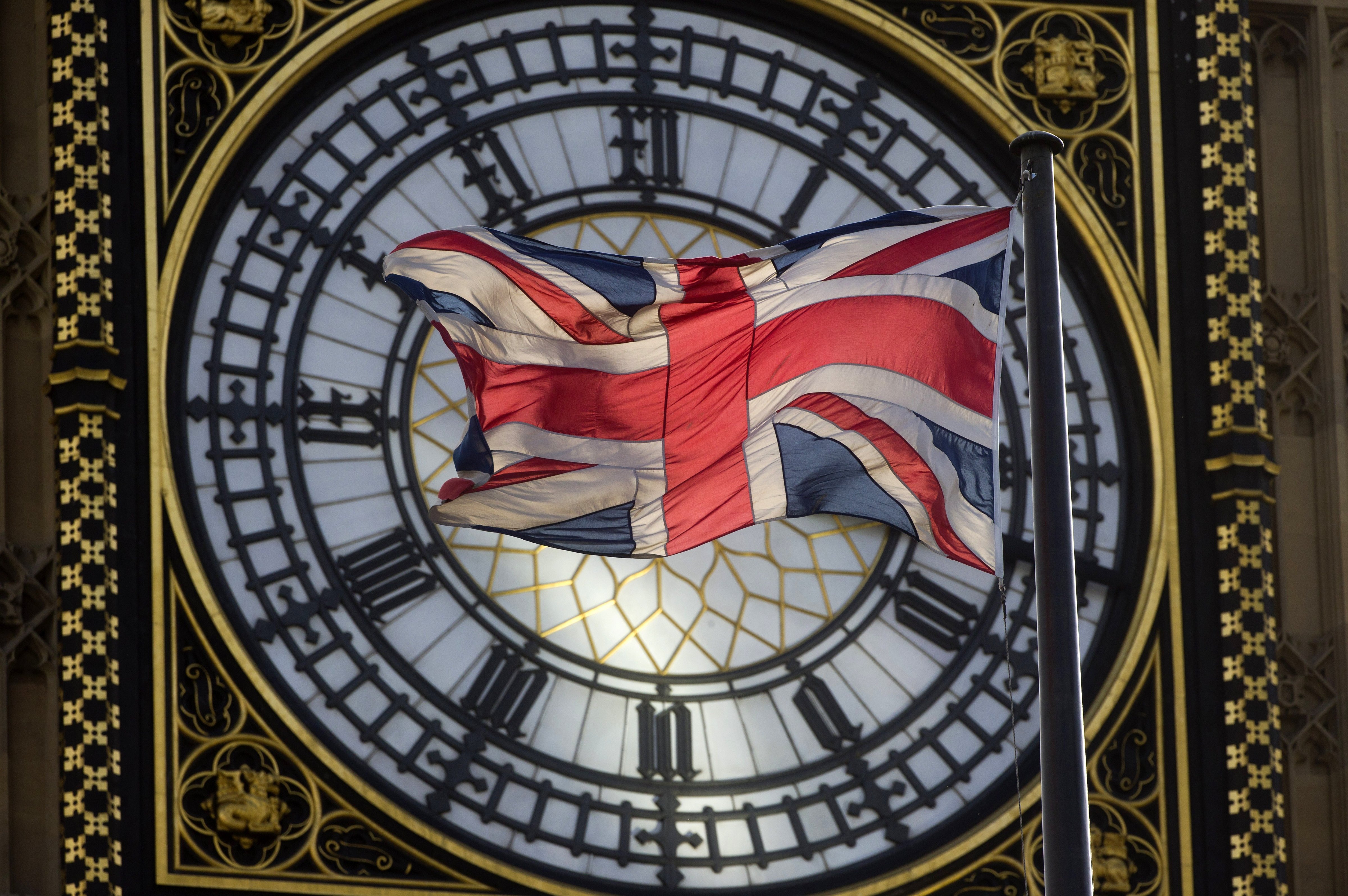 The Union flag is seen flapping in the wind in front of one of the faces of the Great Clock atop the landmark Elizabeth Tower that houses Big Ben at the Houses of Parliament. (Justin Tallis&mdash;AFP/Getty Images)
