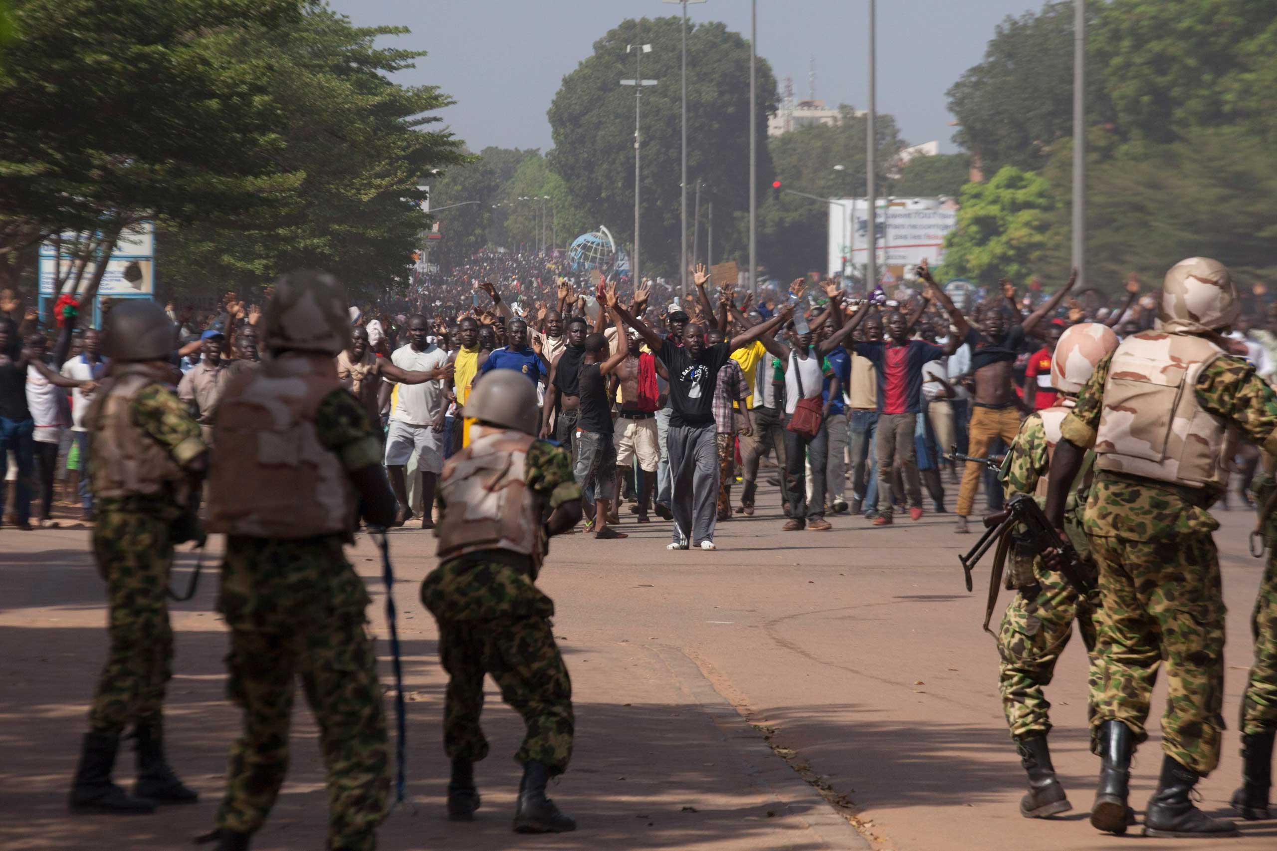 Soldiers attempt to stop anti-government protesters from entering the parliament building in Ouagadougou, capital of Burkina Faso, Oct. 30, 2014.