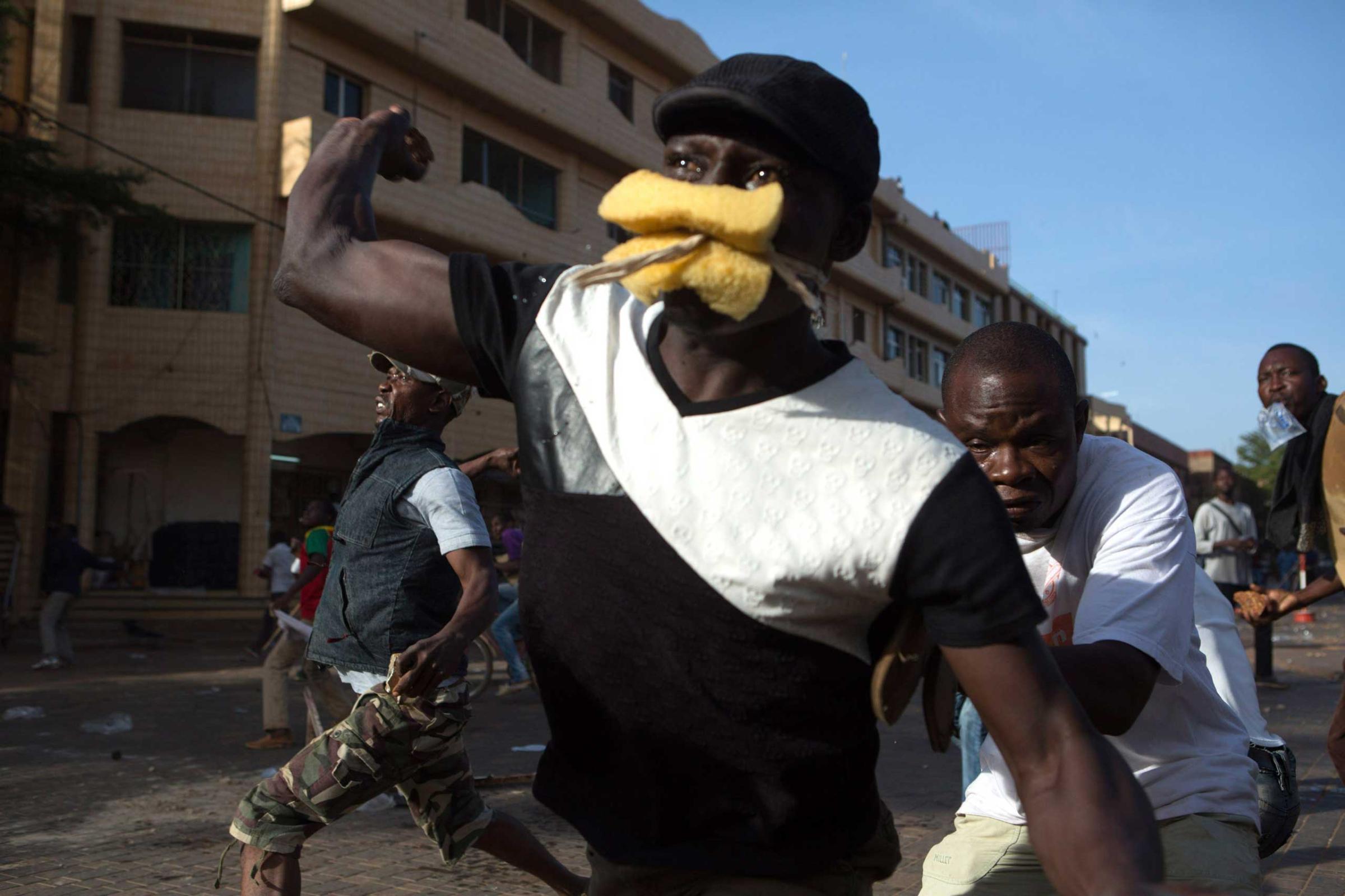 Anti-government protesters throw rocks at police in Ouagadougou, capital of Burkina Faso, Oct. 30, 2014.