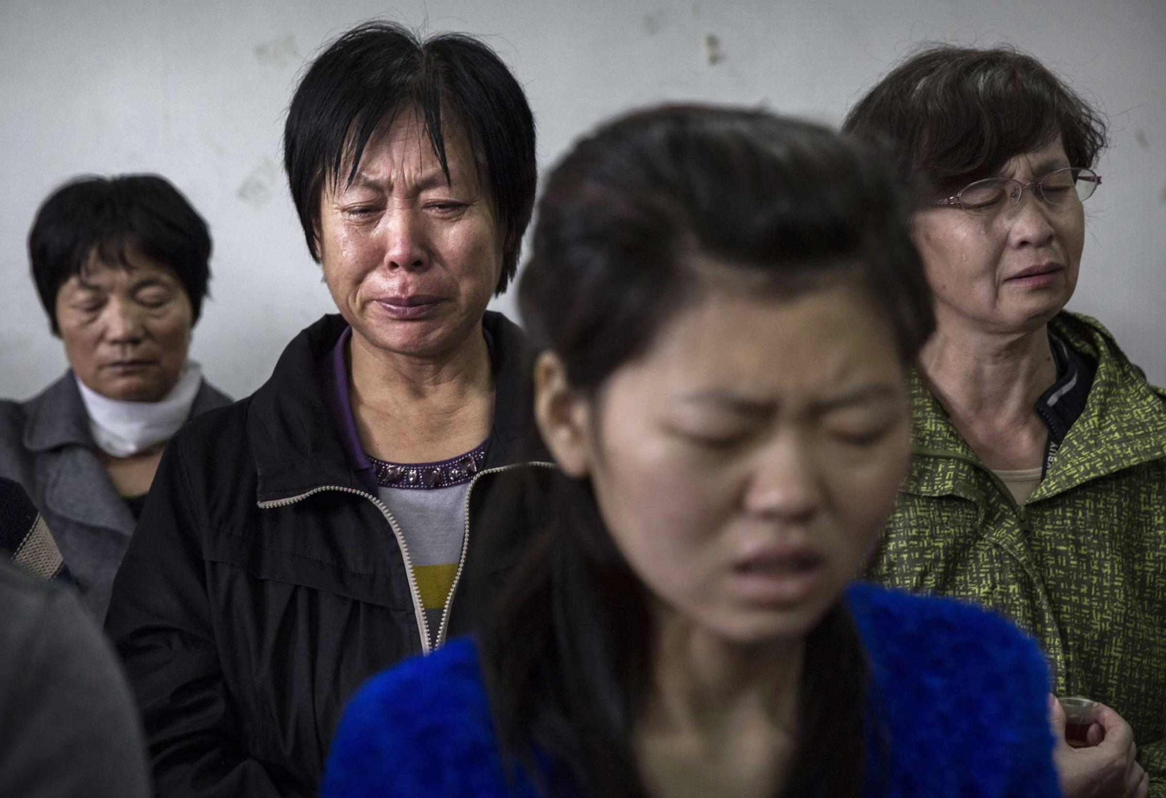 A woman weeps as she and others pray during a service.