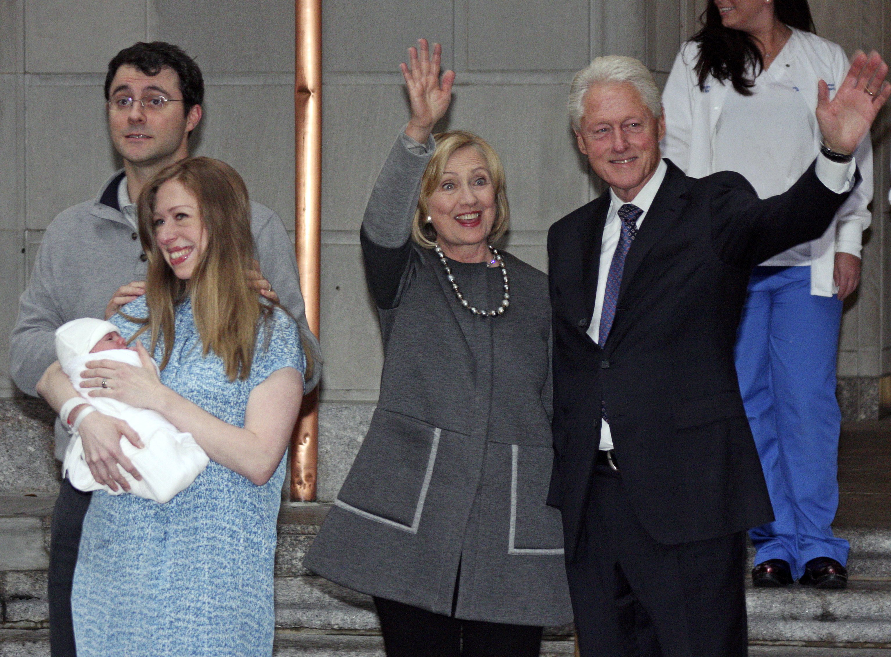 Former President Bill Clinton, right, and former Secretary of State Hillary Rodham Clinton, second from right, wave to the media as Marc Mezvinsky and Chelsea Clinton pose for photographers with their newborn baby, Charlotte, after the family leaves Manhattan's Lenox Hill hospital in New York City on Sept. 29, 2014. (William Regan—AP)