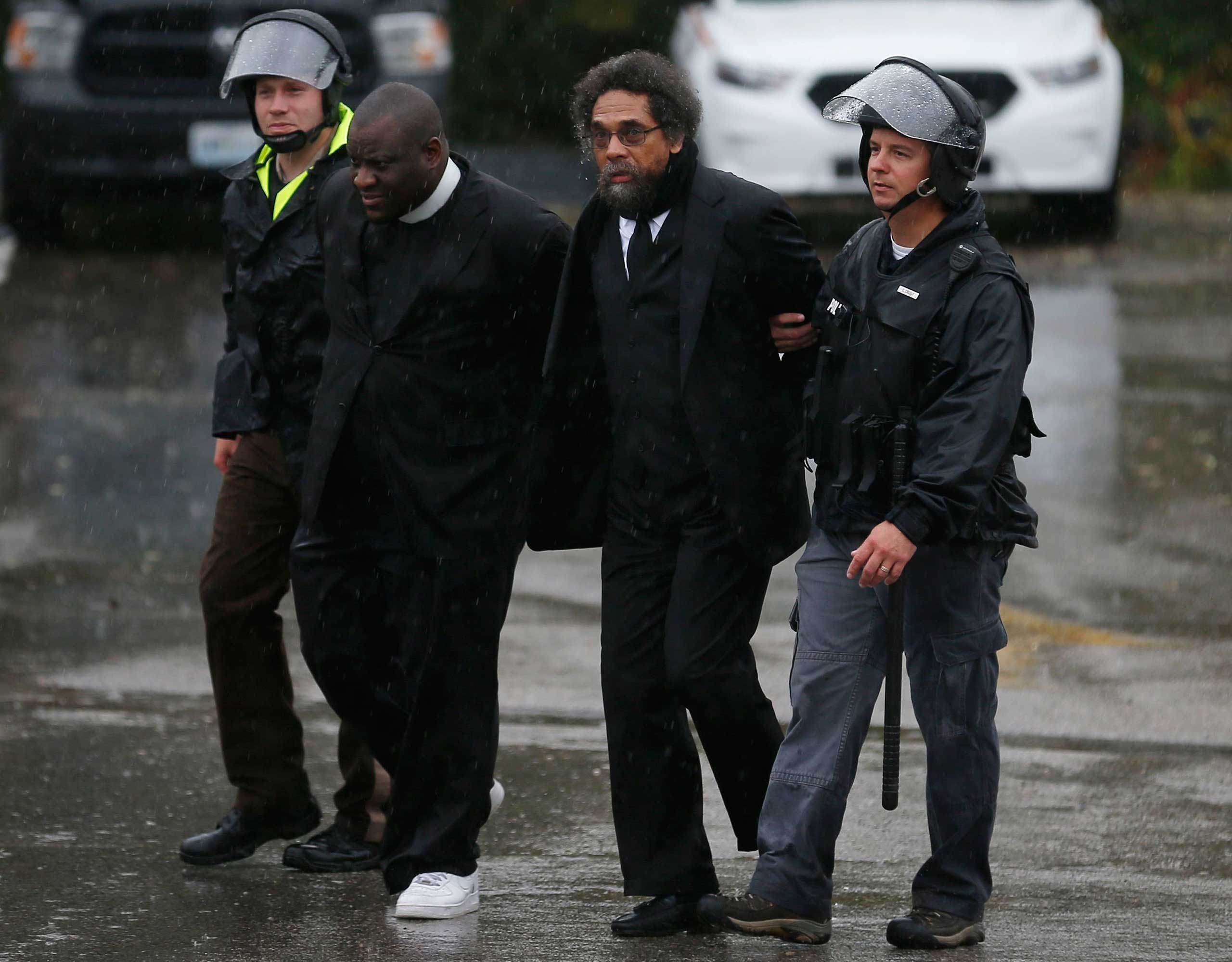 Activist Cornel West is detained by police during a protest at the Ferguson Police Department in Ferguson