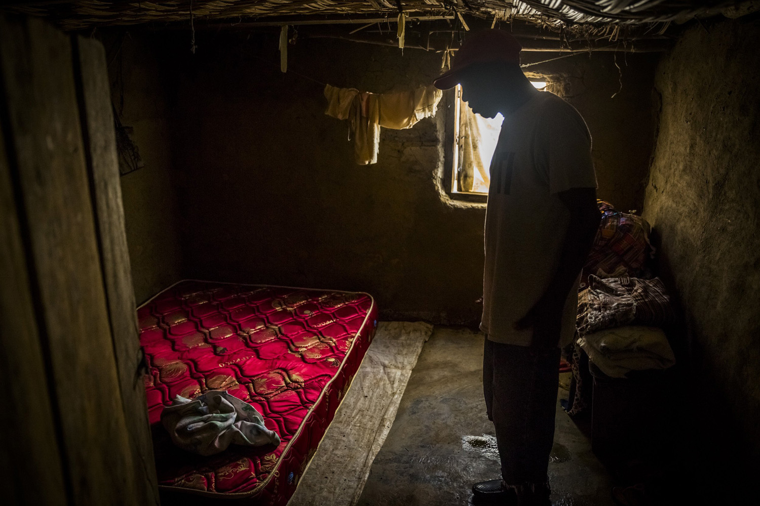John Yarkpawolo looks over the body of four-day-old Diana Dormeyan, his granddaughter, whose mother died while giving birth to her, at their family home in Gbarnga, Liberia, Oct. 8, 2014.