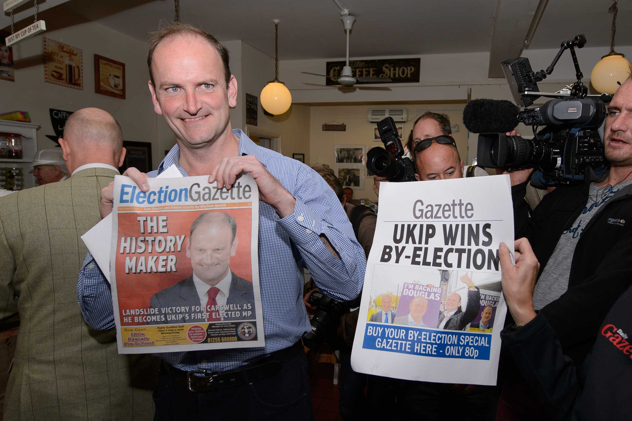 Newly-elected UK Independence Party MP Douglas Carswell poses for photographers with a copy of the local paper in Clacton-on-Sea, in eastern England, on Oct. 10, 2014. (Leon Neal—AFP/Getty Images)