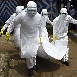 Red Cross workers carry away the body of a person suspected of dying from the Ebola virus, in the Monrovia, Liberia on Oct. 4, 2014.