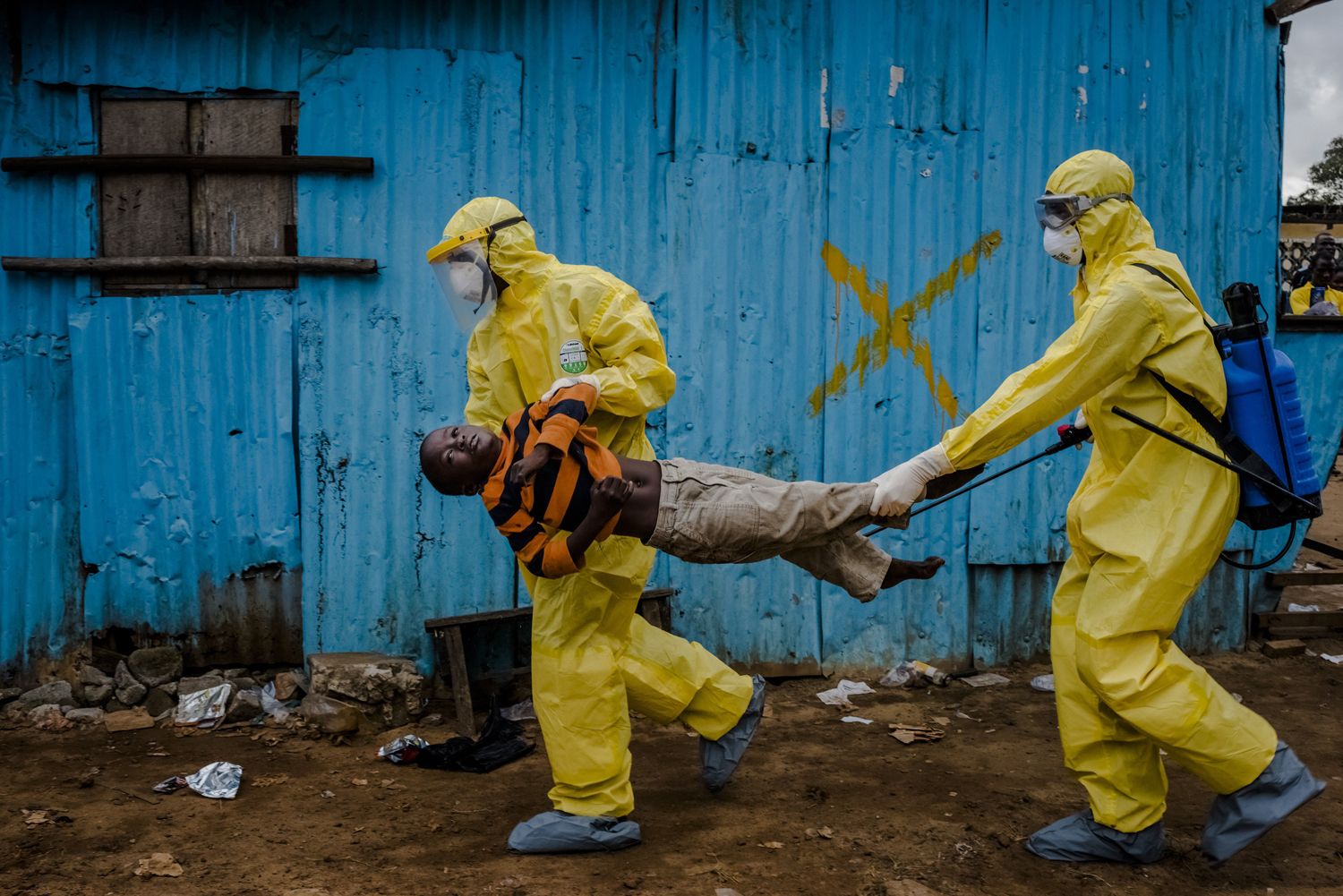 Medical staff carry James Dorbor, 8, suspected of having Ebola, into a treatment facility in Monrovia, Liberia, Sept. 5, 2014. (Daniel Berehulak—The New York Times/Redux)