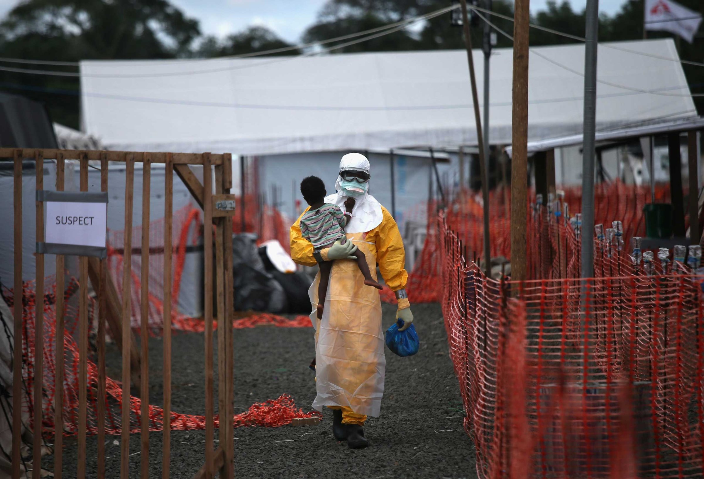 A Doctors Without Borders (MSF), health worker in protective clothing carries a child suspected of having Ebola in the MSF treatment center on Oct. 5, 2014 in Paynesville, Liberia.