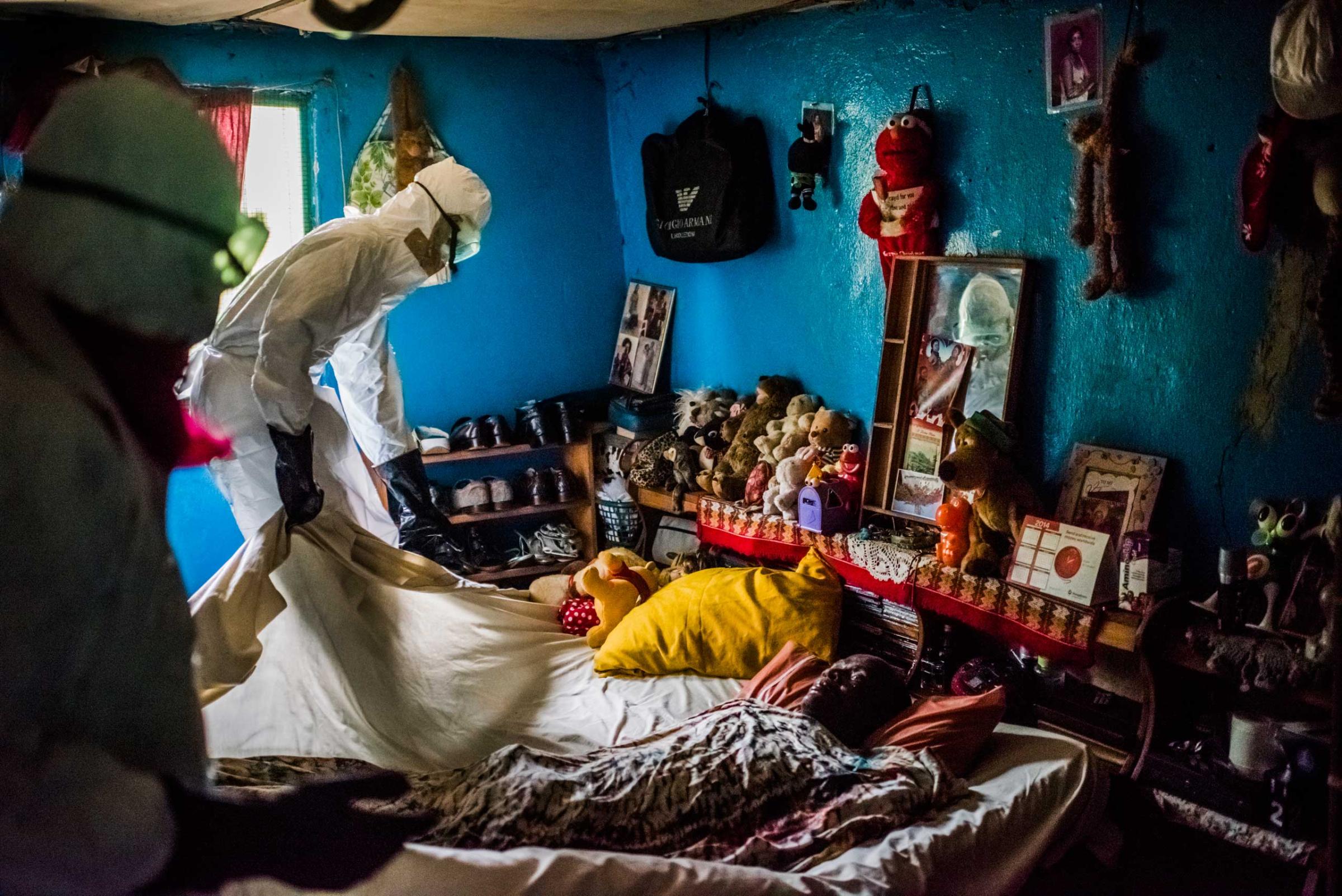 Members of a burial team from the Liberian Red Cross remove the body of a man, a suspected Ebola victim, from a home in Matadi on Sept. 17, 2014 in Monrovia, Liberia.