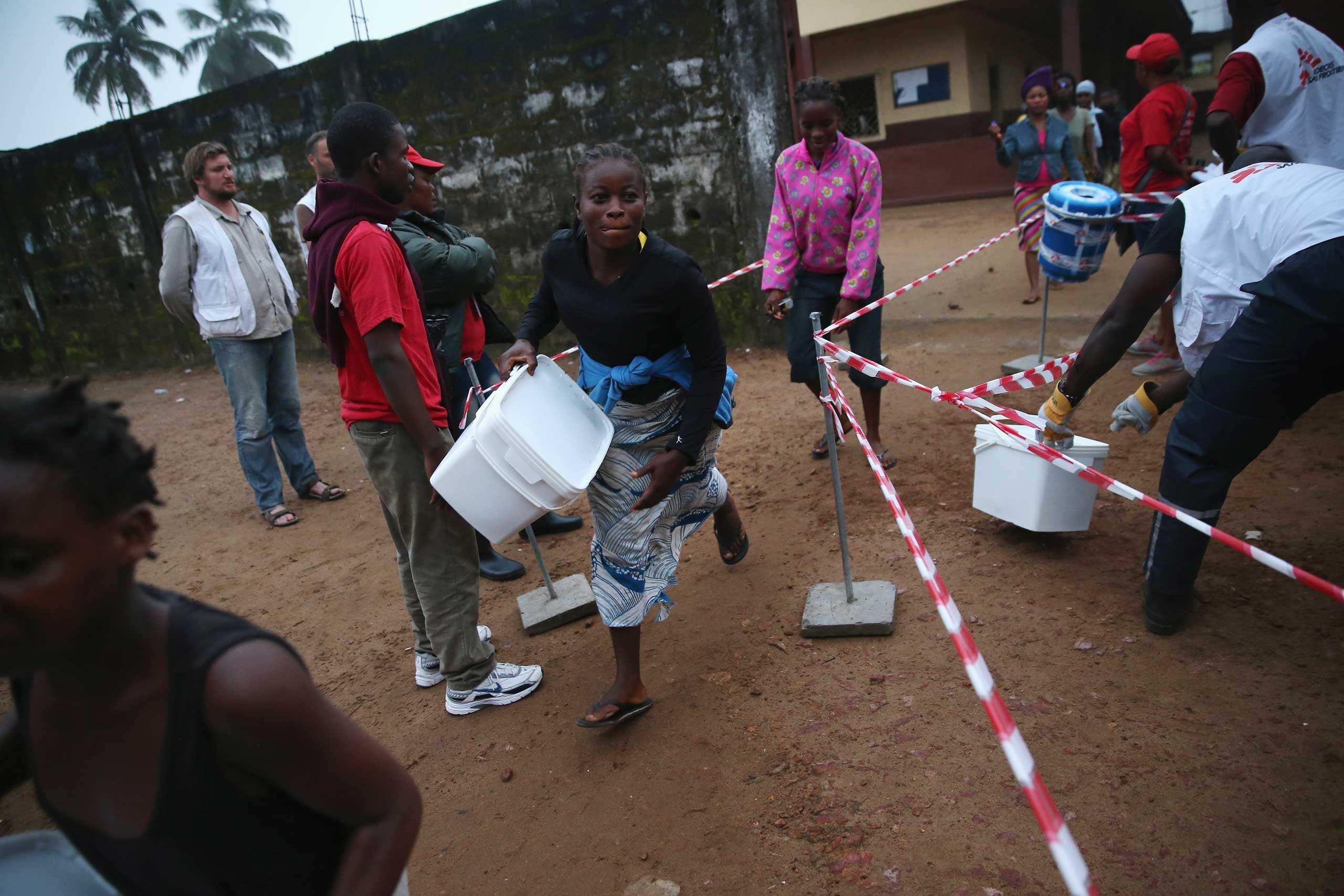 Residents take home family and home disinfection kits distributed by Doctors Without Borders, on Oct. 4, 2014 in New Kru Town, Liberia. (John Moore—Getty Images)