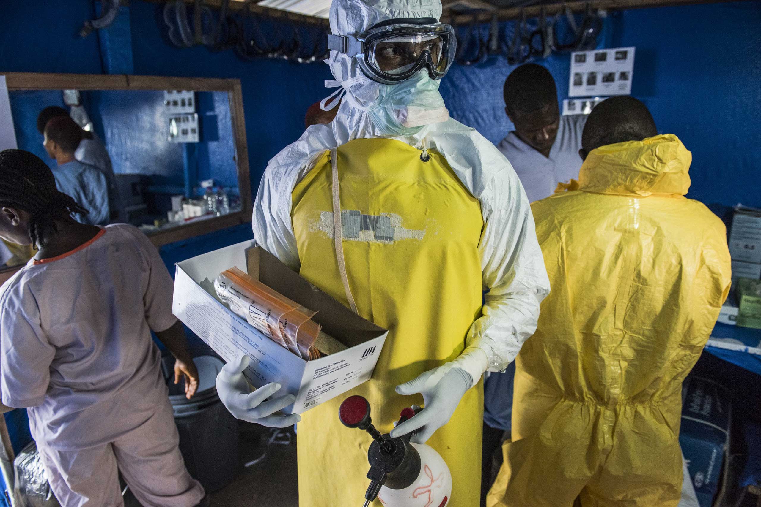A health worker in protective gear carries empty blood sample kits at the Bong County Ebola treatment center in Suakoko, Liberia, Oct. 19, 2014. (Daniel Berehulak—Redux/The New York Times)