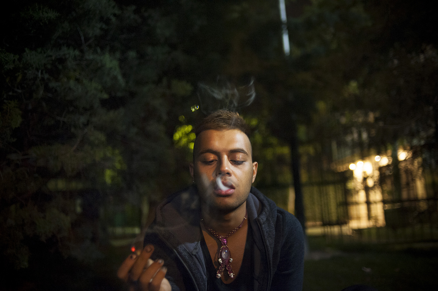 Only a few nights to his departure, Amir hangs out with his friend in a park late at night and smokes a joint to relax. Tehran, Iran.