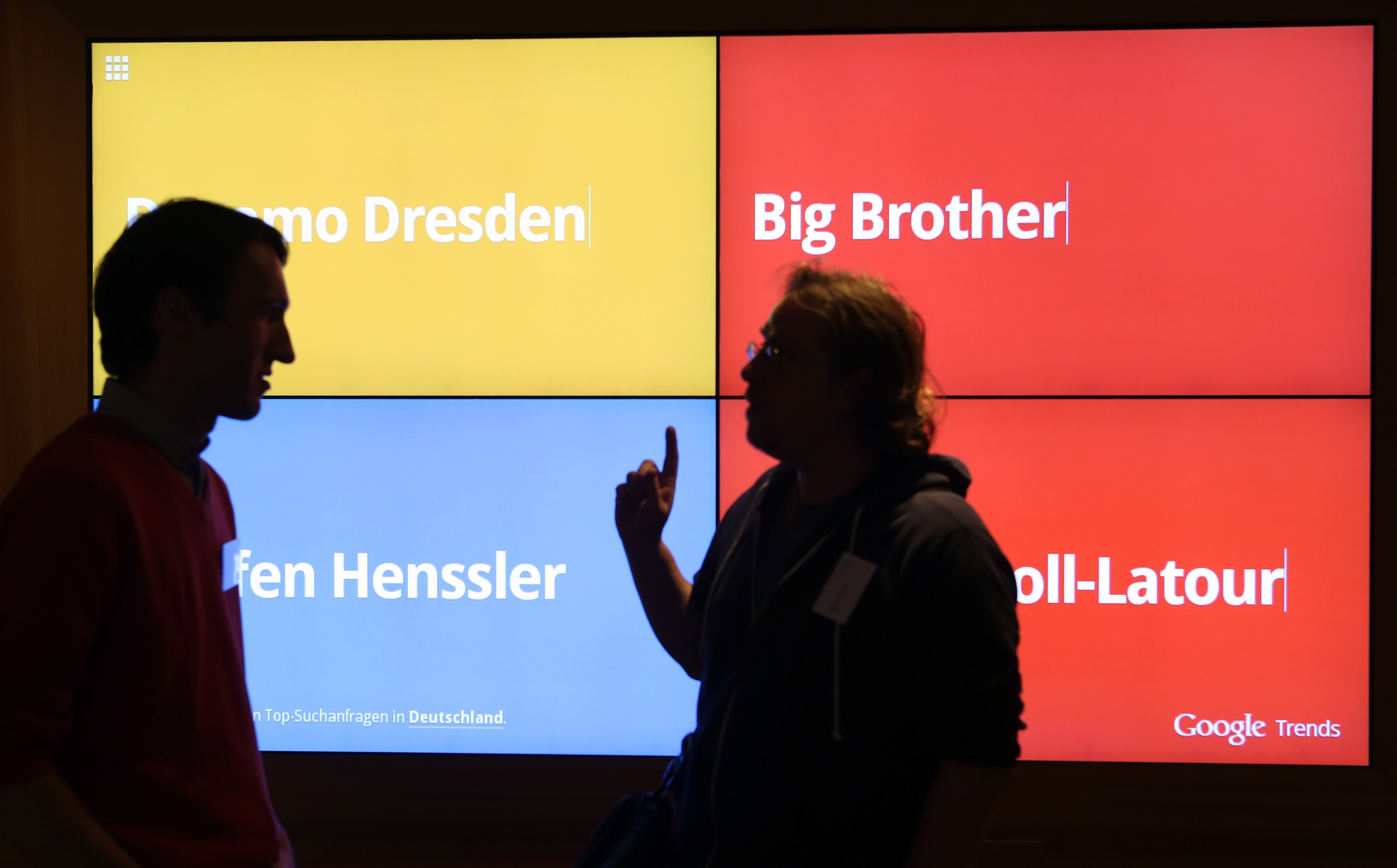 Visitors stand in front of a screen showing the most popular Google searches in Germany at that moment in the company's offices on Aug. 21, 2014 in Berlin.