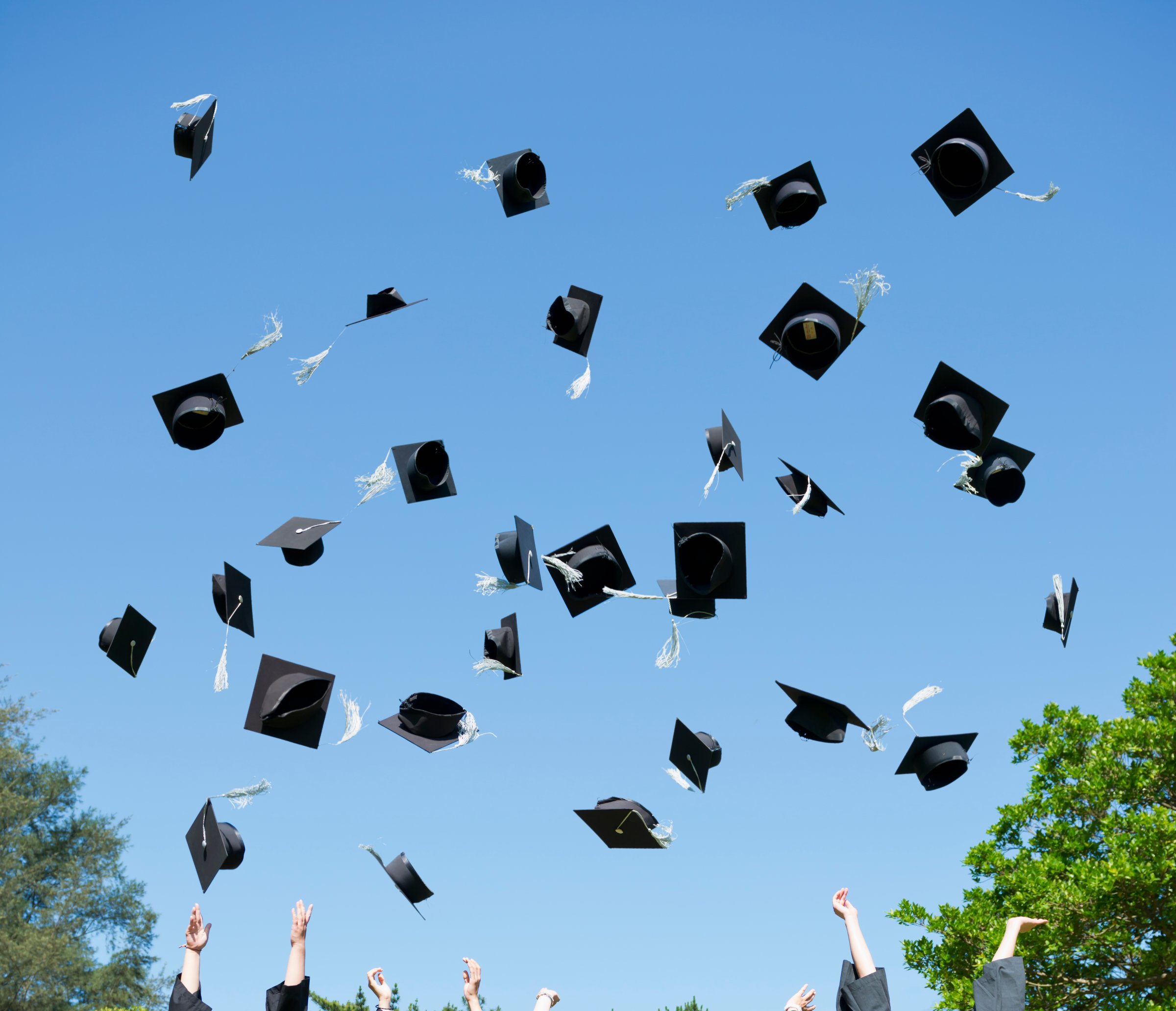 Graduates throwing caps in air