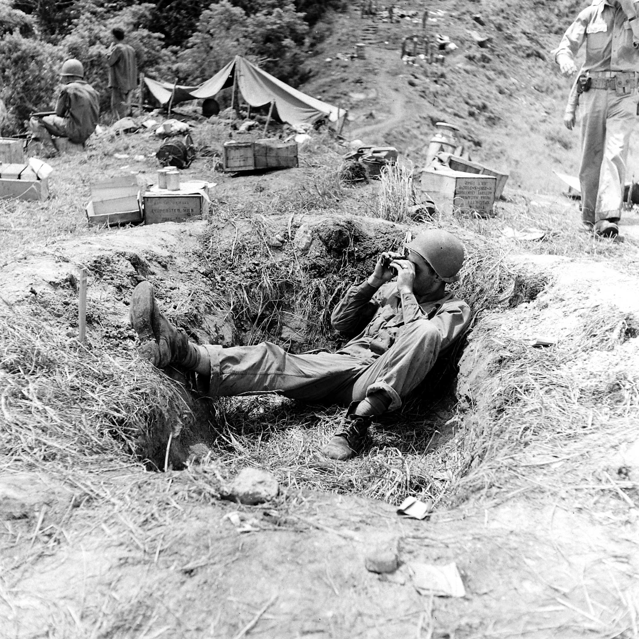 "A lookout on Burnt Knoll makes himself comfortable in an old shell hole."