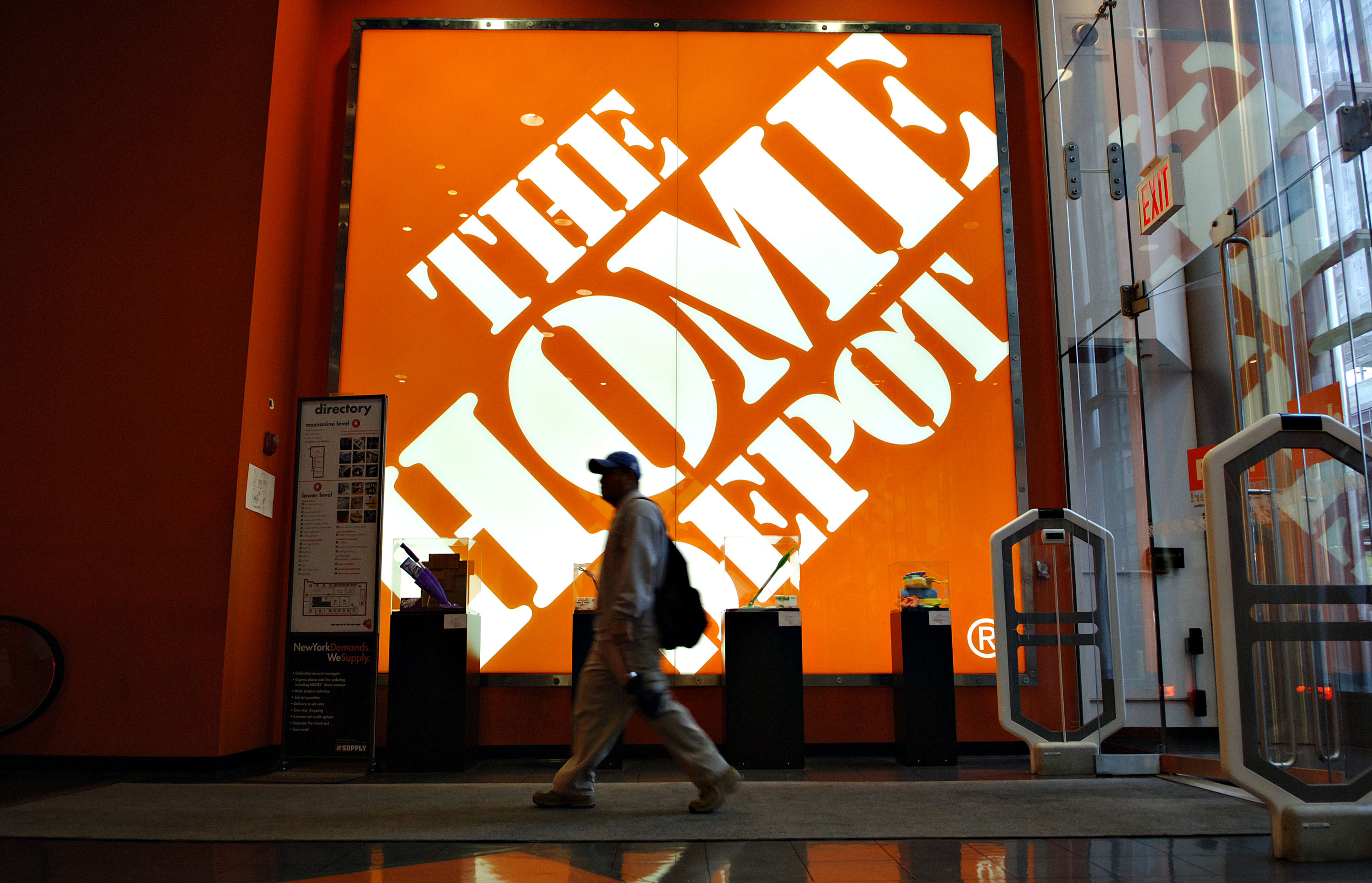 A shopper walks past a large Home Depot logo inside a store in New York on May 16, 2006.
