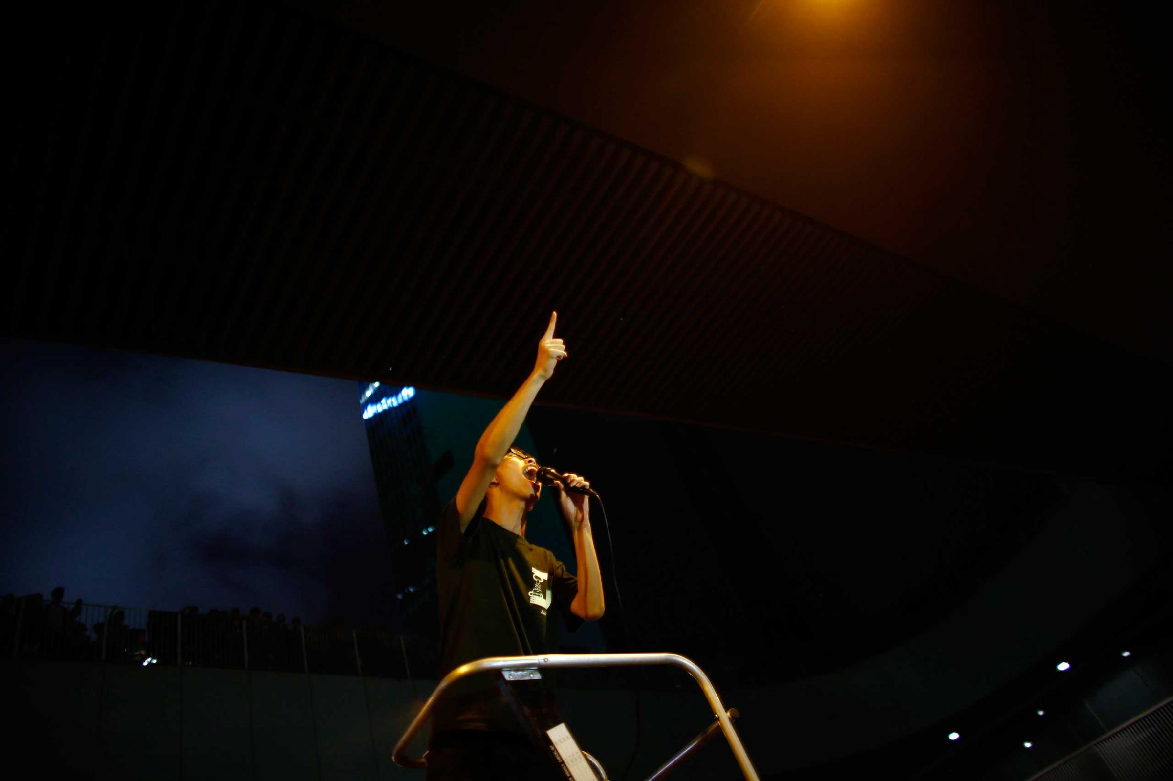 Joshua Wong, leader of the student movement, delivers a speech as protesters block the main street to the financial Central district, outside the government headquarters building in Hong Kong Oct. 1, 2014.
