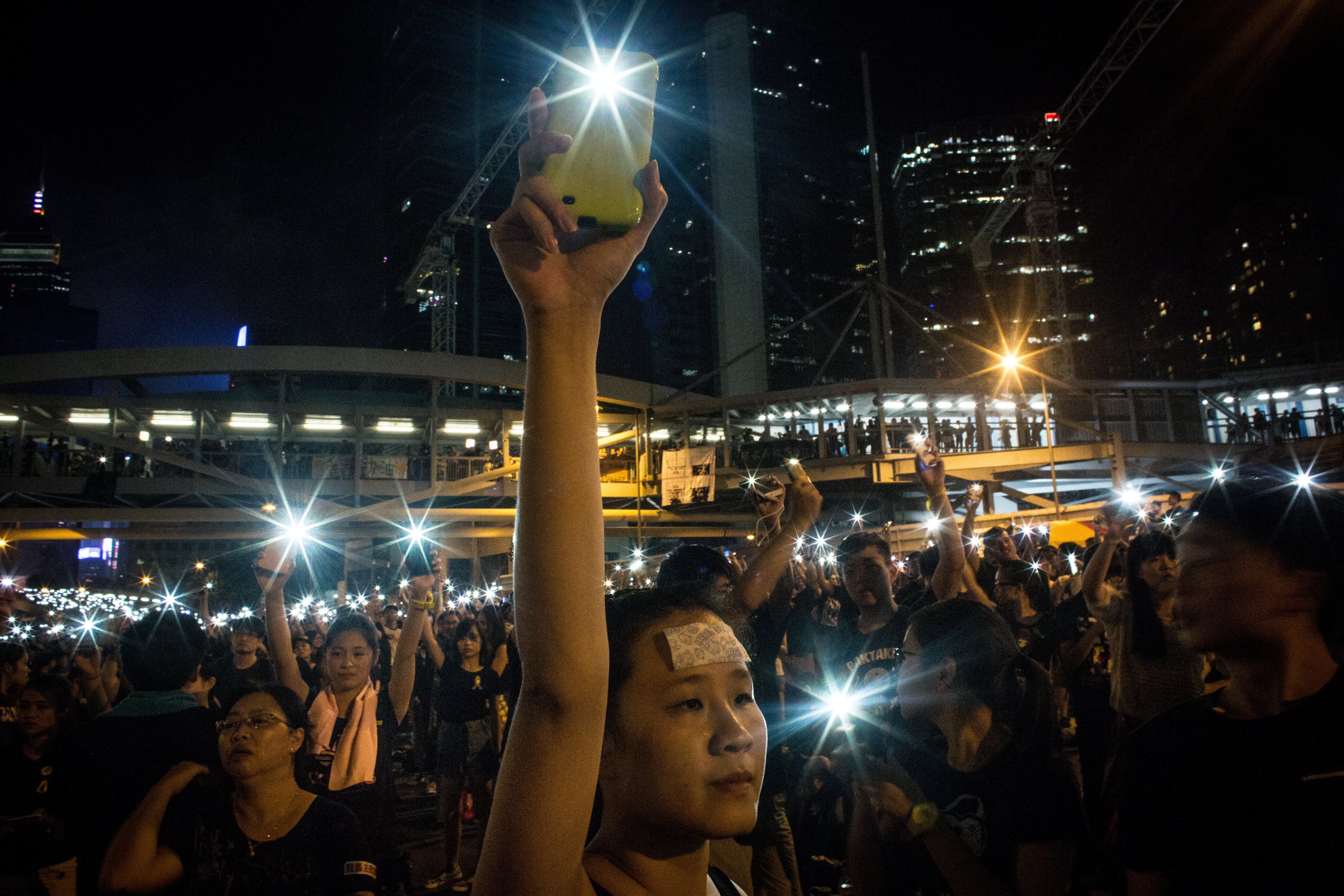 A protester waves her cell phone in the air outside the Hong Kong Government Complexon October 1, 2014 in Hong Kong, Hong Kong. (Chris McGrath&mdash;Getty Images)