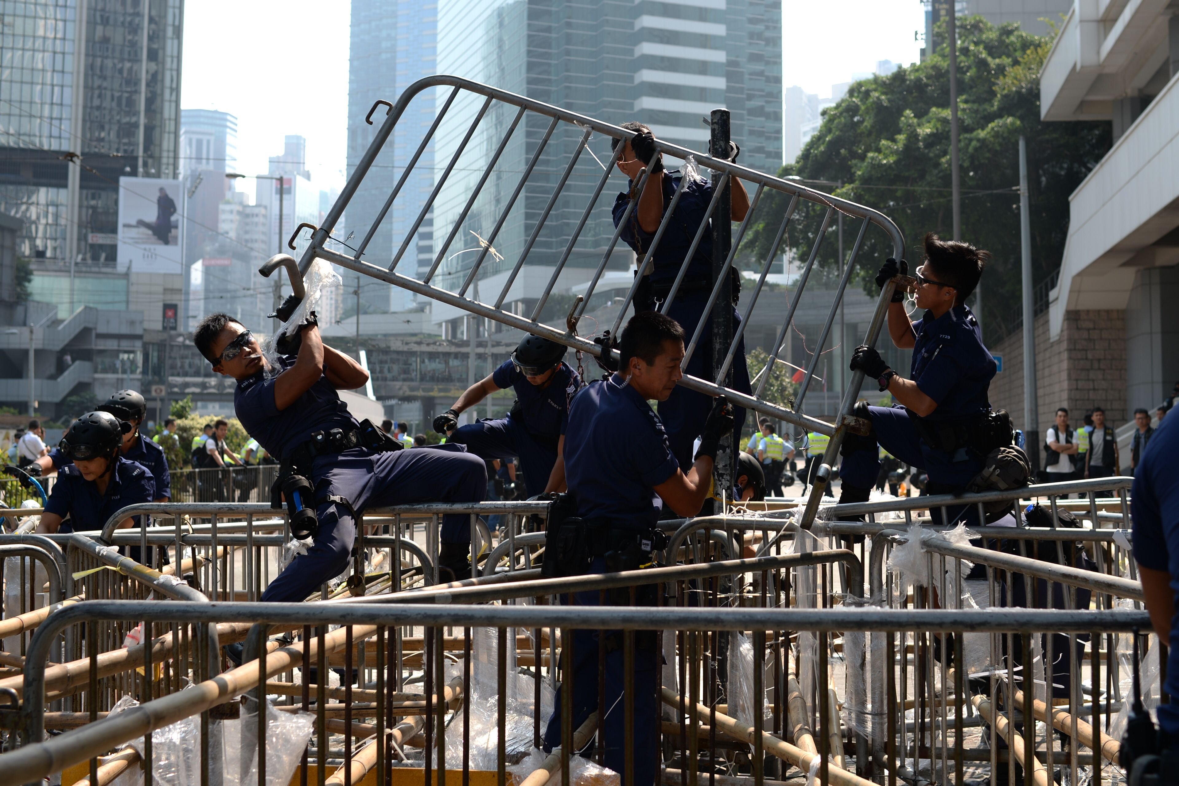 Police officers remove barricades of pro-democracy protestors in the Admiralty district of Hong Kong on Oct. 14, 2014. (Pedro Ugarte—AFP/Getty Images)