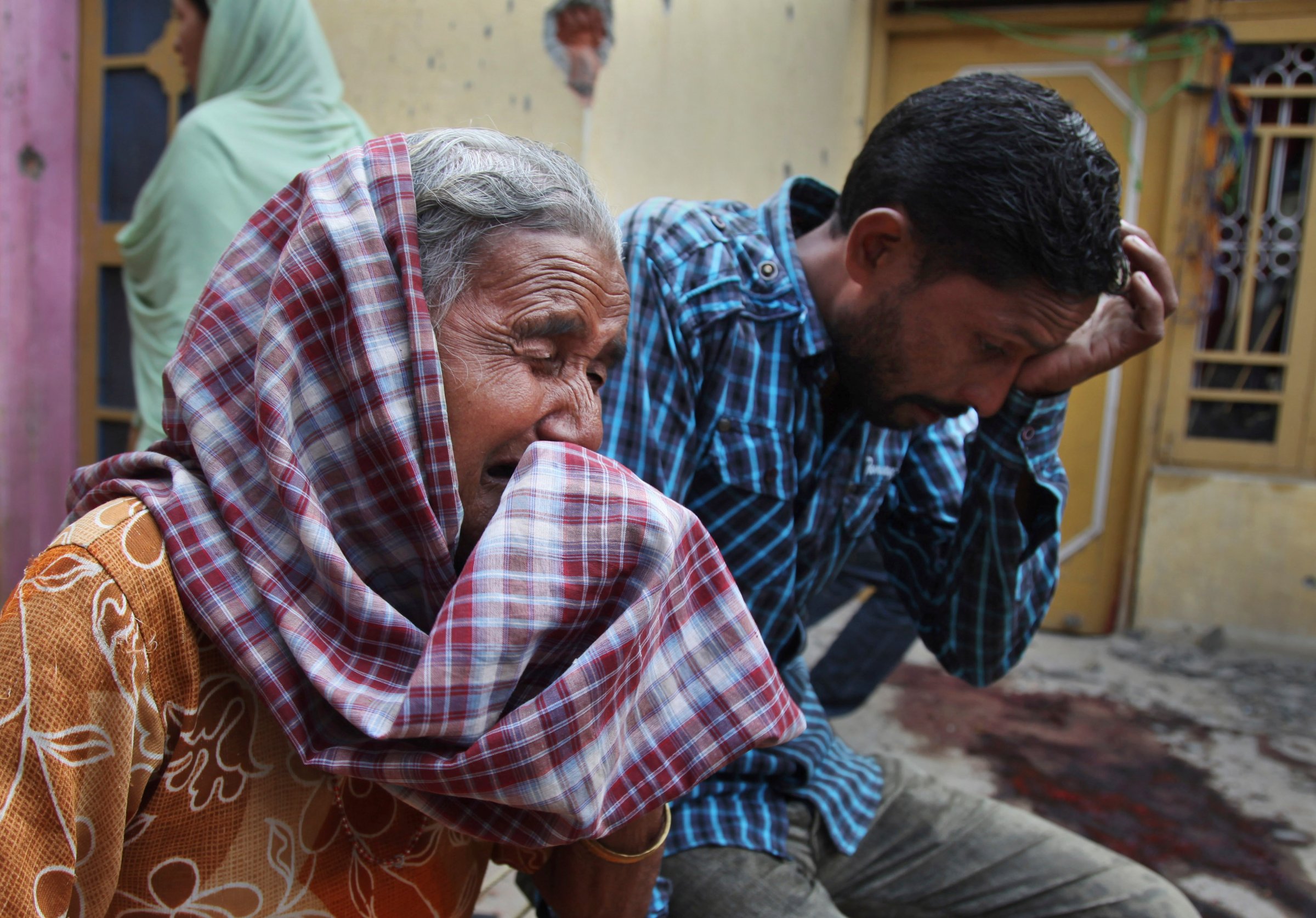 Relatives of Rajesh Kumar, who was killed in mortar shell firing allegedly from the Pakistan's side, weep inside their residential house at Masha da kothe village, in Arnia Sector near the India-Pakistan international border, about 30 miles)from Jammu, India, on Monday.