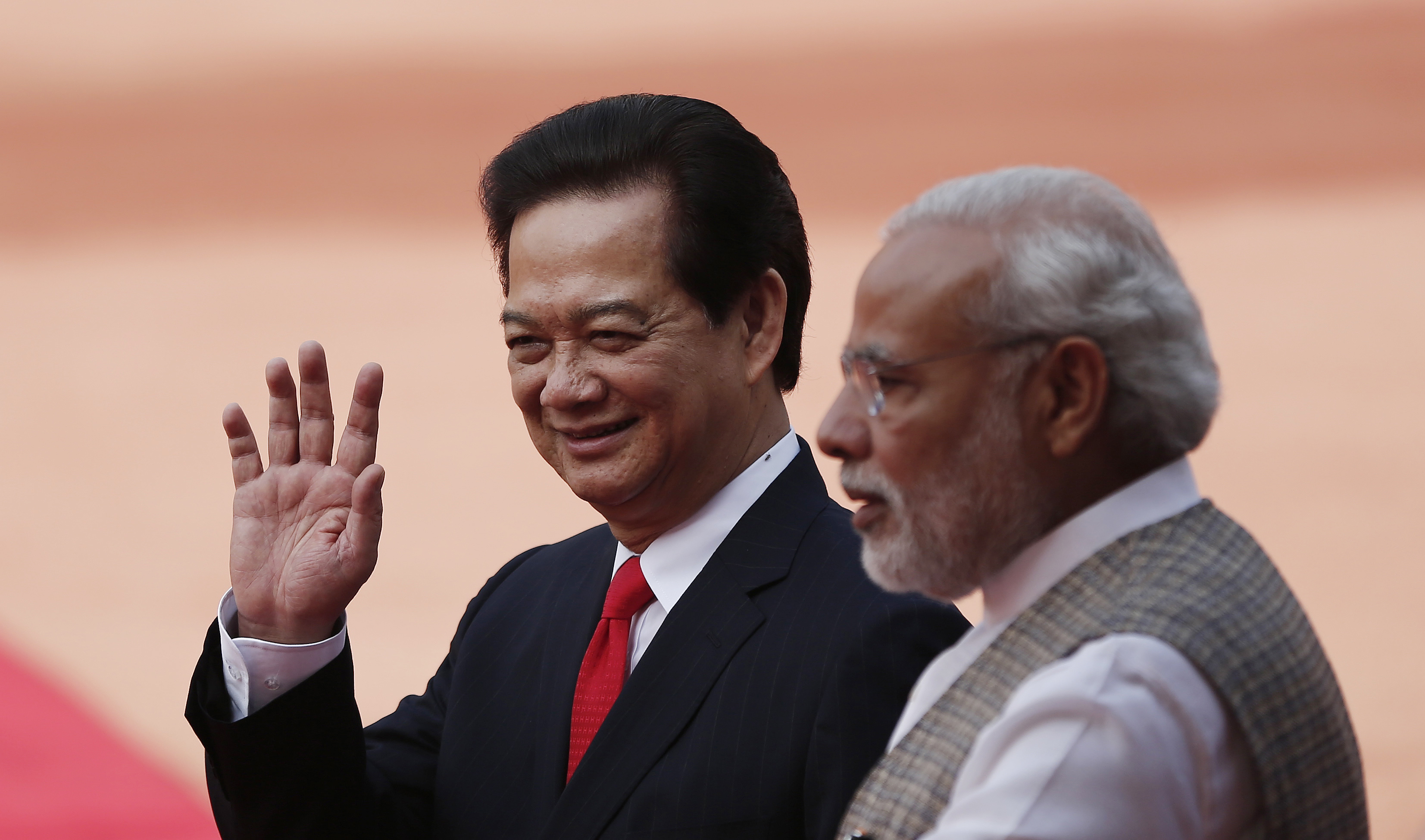 Vietnam's Prime Minister Nguyen Tan Dung waves next to his Indian counterpart Narendra Modi during Dung's ceremonial reception at the forecourt of India's presidential palace in New Delhi on Oct. 28, 2014 (Adnan Abidi—Reuters)