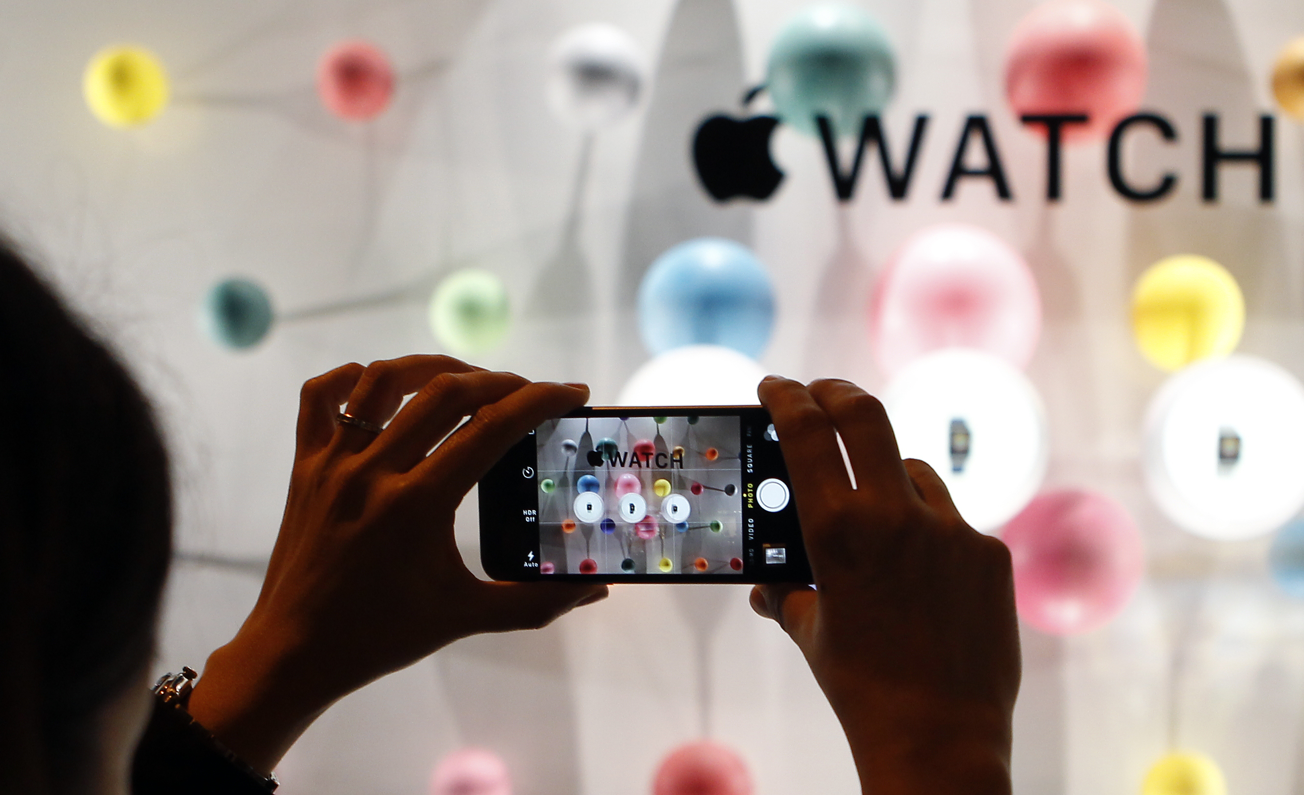 A woman takes a picture during the new Apple Watch display during an Apple special event at Colette store on September 30, 2014 in Paris, France. (Chesnot&mdash;Getty Images)