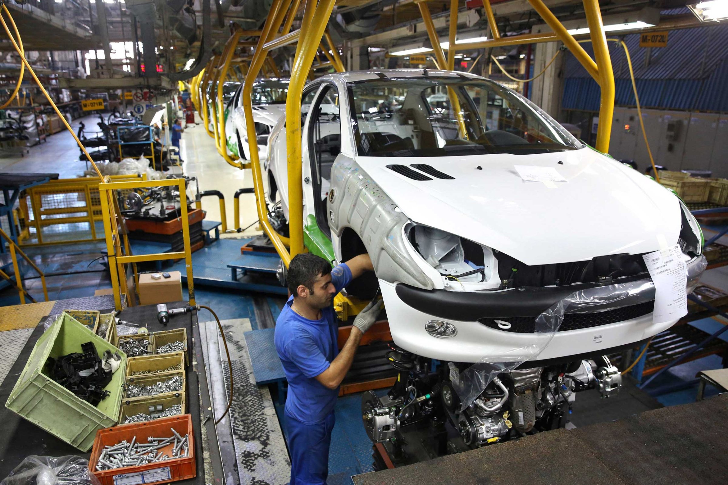 An Iranian worker assembles a Peugeot 206 at the state-run Iran-Khodro automobile manufacturing plant near Tehran, Iran, Oct. 11, 2014.