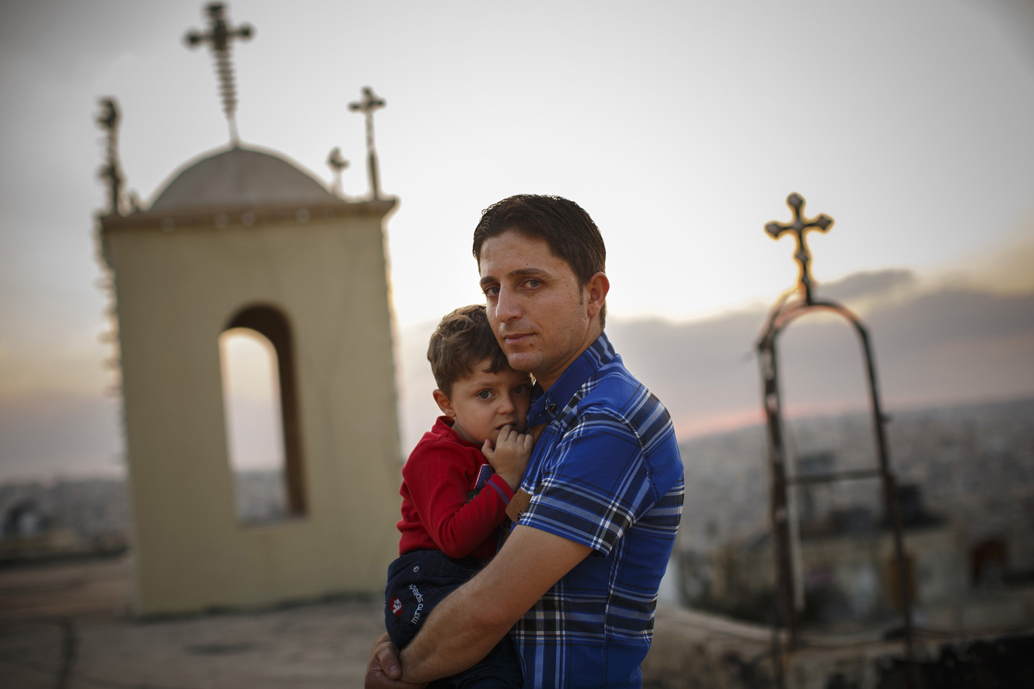 Radwan Shamra, Iraqi Christian refugee, with his son, Martin, 3, on the roof of St. Ephraim Syrian Orthodox Church in Amman, Jordan, Oct. 1, 2014.
